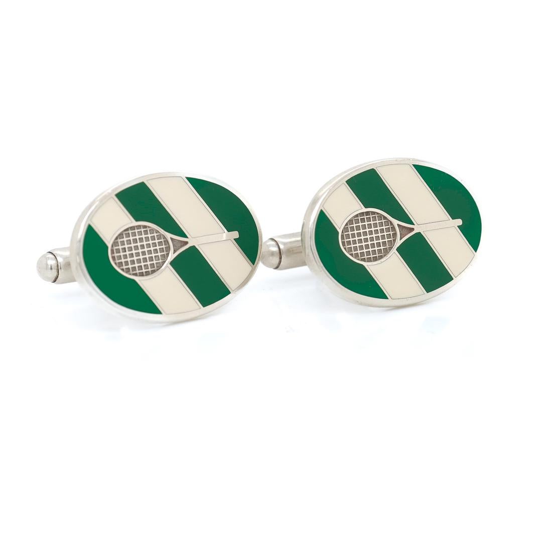 A fine pair of Tennis related cufflinks

By Tiffany & Co.

In sterling silver.

Each head with white and green enamel inlay and a tennis racquet with recessed strings to its center.

Marked for Tiffany & Co / Sterling / 925 to the reverse.

Simply