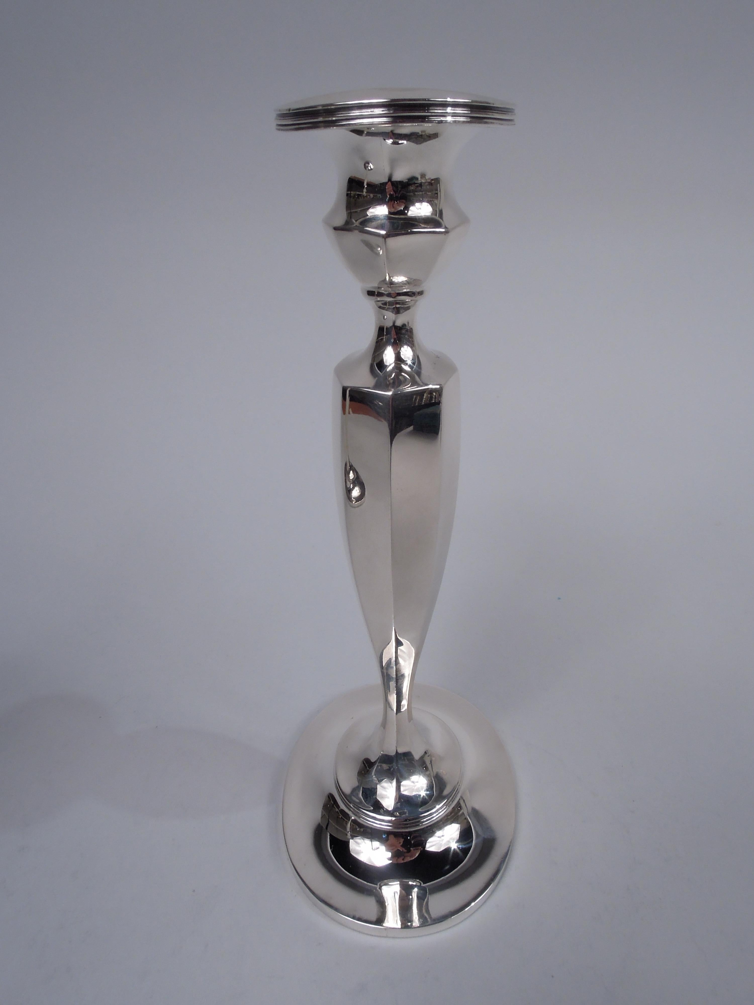 Pair of American Edwardian Georgian sterling silver candlesticks, ca 1910. Retailed by Tiffany & Co. in New York. Bellied socket with bobeche on tapering shaft mounted to domed foot. Ovoid, faceted, and reeded. Fully marked including retailer’s