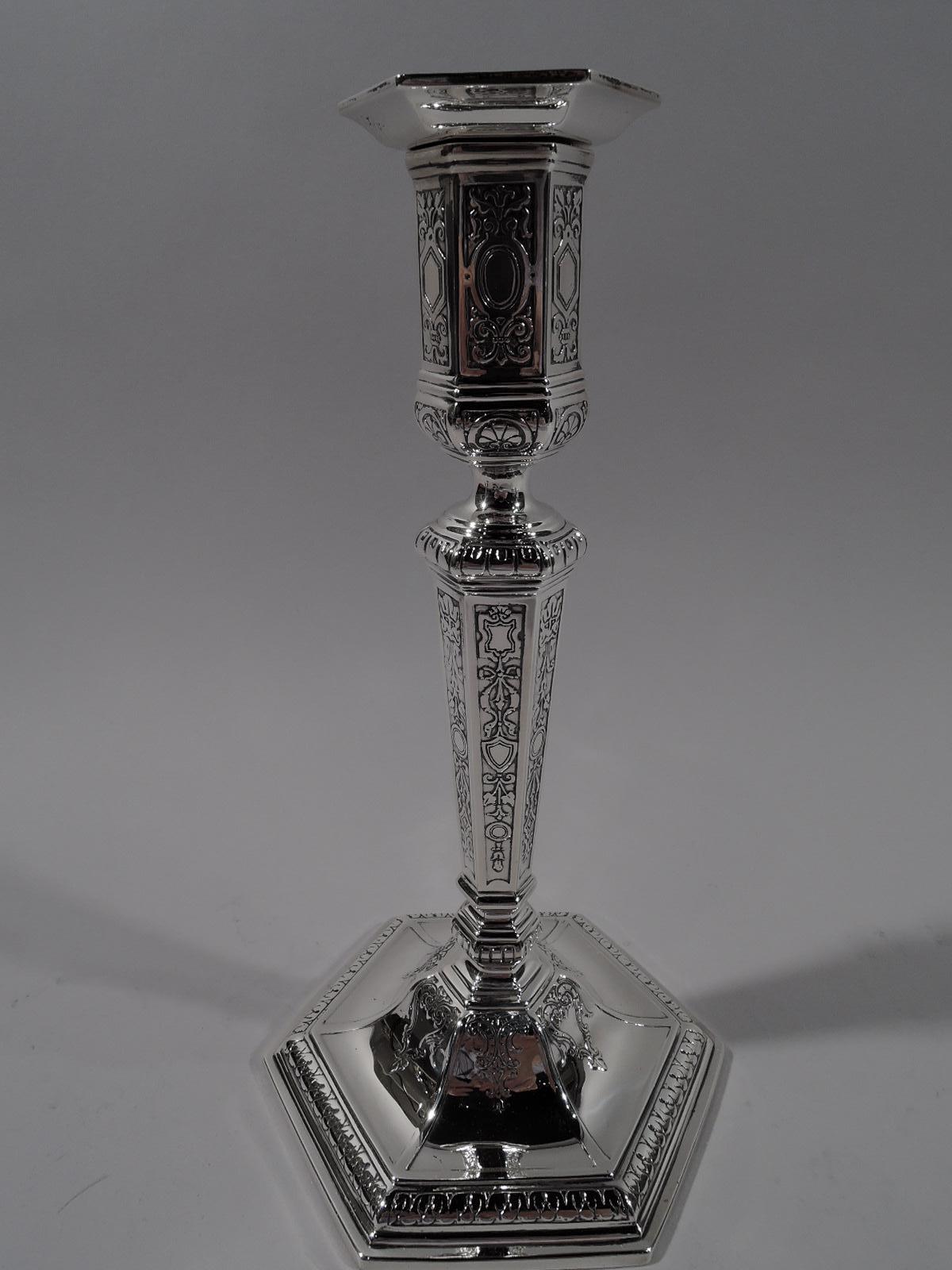 Pair of Edwardian sterling silver candlesticks. Made by Tiffany & Co. in New York, circa 1915. Each: Tapering shaft on raised foot. Socket has straight sides and detachable bobeche. Faceted. Acid-etched flowers, ribbon, and paterae. Leaf-and-dart