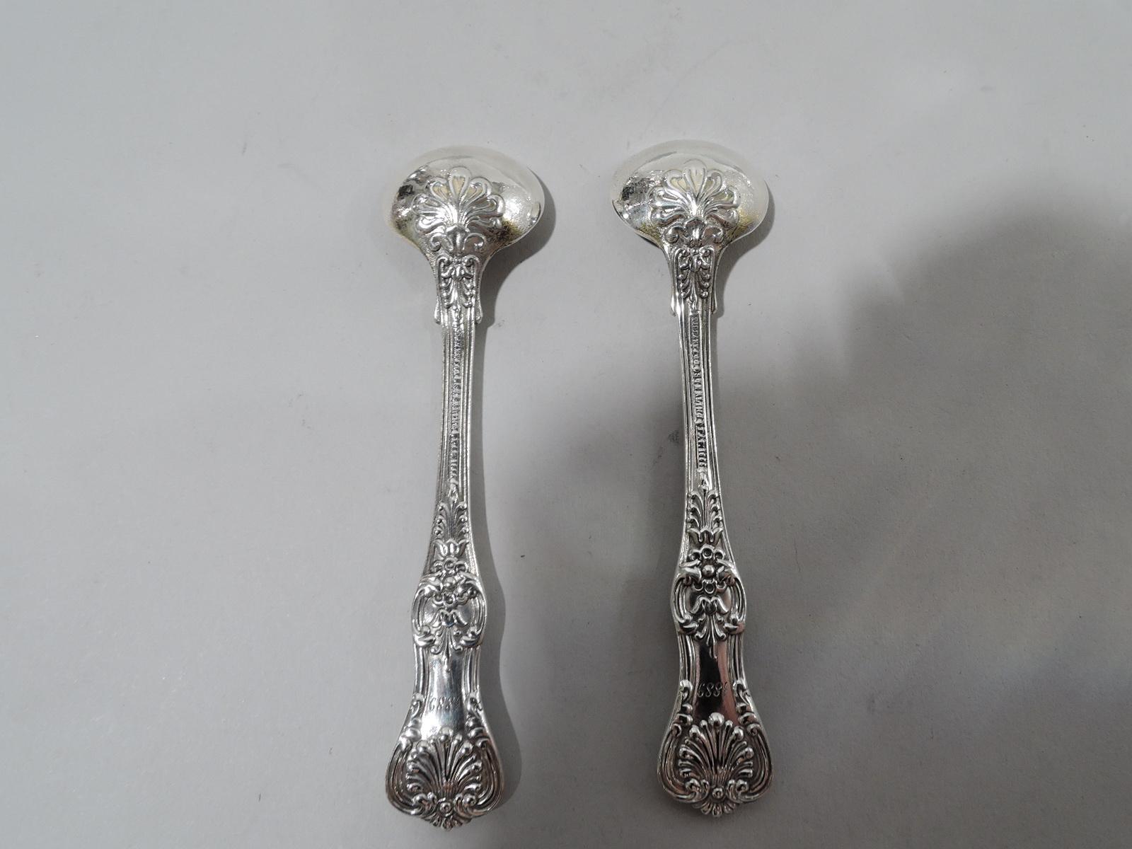 Pair of English King sterling silver master salt spoons. Made by Tiffany & Co. in New York, ca 1885. Each: Tapering and waisted terminal with double-sided scallop shells and flowers. Engraved script monogram (front) and year 1889 (back). Round bowl.