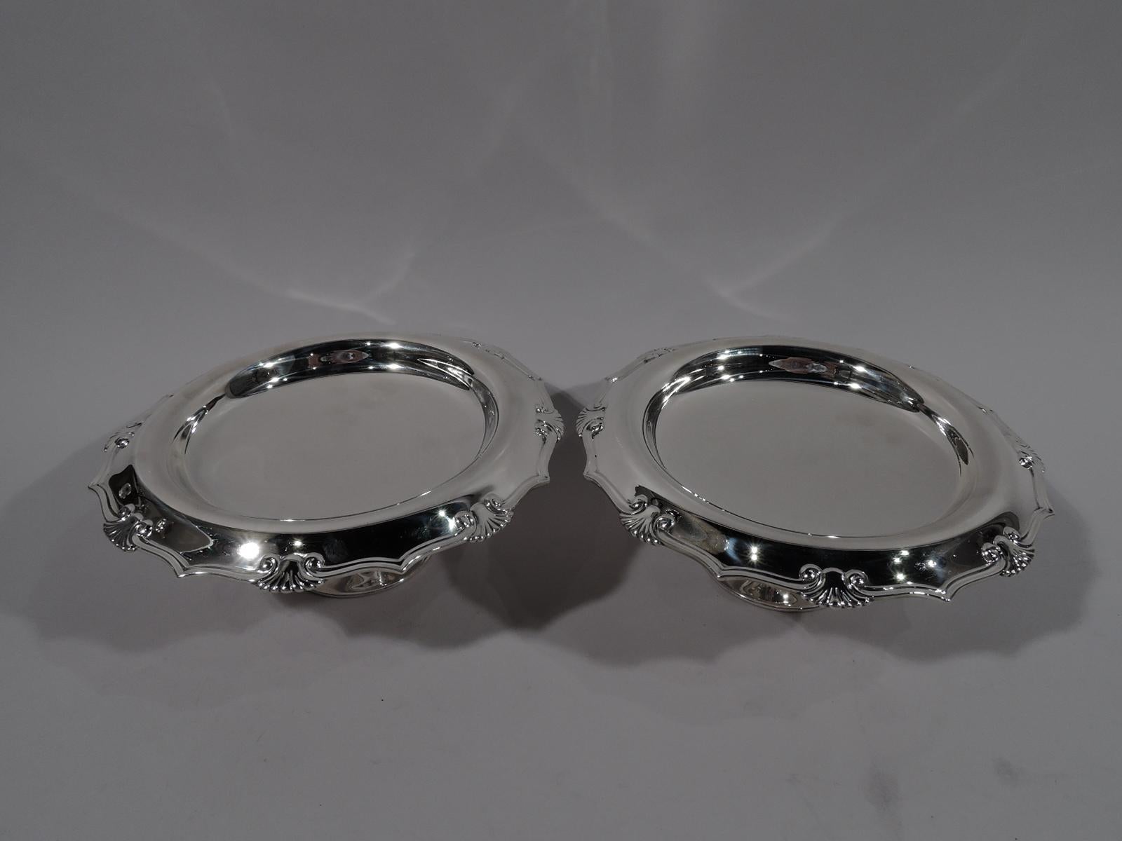 Modern Classical sterling silver compotes. Made by Tiffany & Co. in New York, circa 1910. Each: Deep well and turned-down molded ogee rim interspersed with stylized scallop shells. Short support flowing into raised foot. Fully marked including