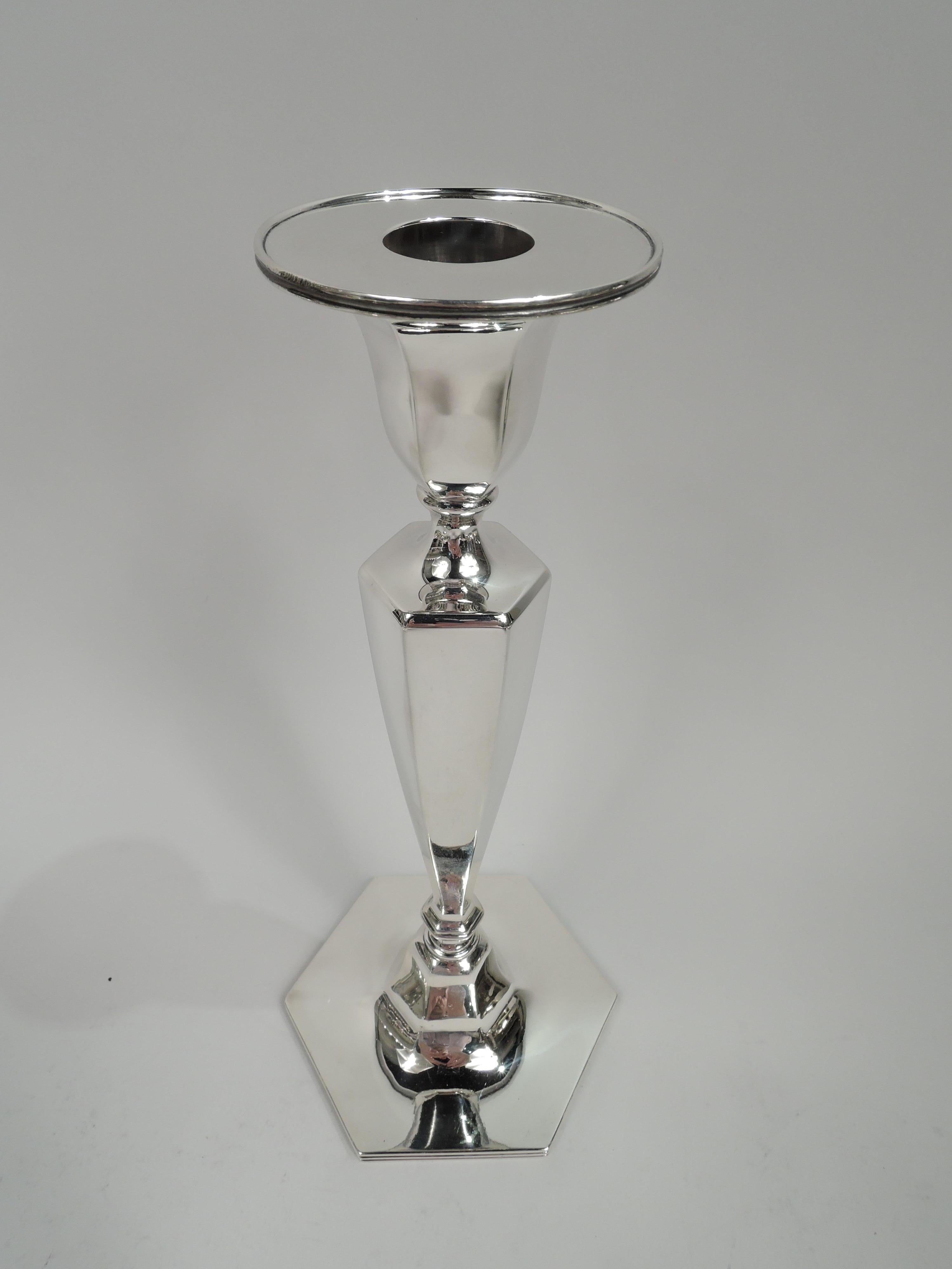 Pair of Modern Georgian sterling silver candlesticks. Made by Tiffany & Co. in New York, ca 1910. Each: Tapering and hexagonal shaft on raised hexagonal foot. Socket same with round detachable bobeche. Bobeche and foot rim reeded. Fully marked