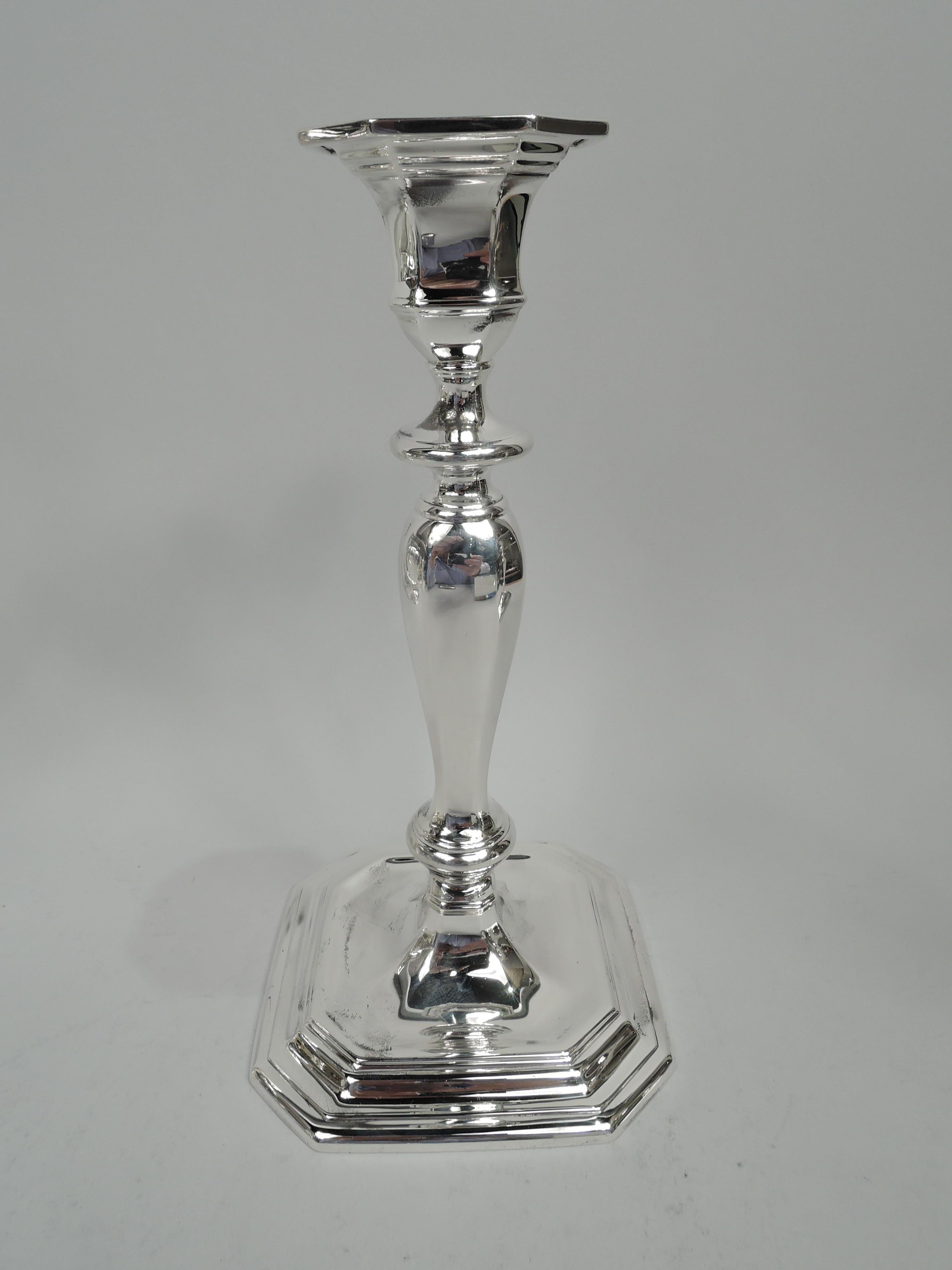 Pair of Georgian sterling silver candlesticks. Made by Tiffany & Co. in New York, ca 1913. Each: Knopped baluster shaft on stepped square base. Urn socket with flat detachable bobeche. Faceting and chamfering. Olden-days form spiffed up for the