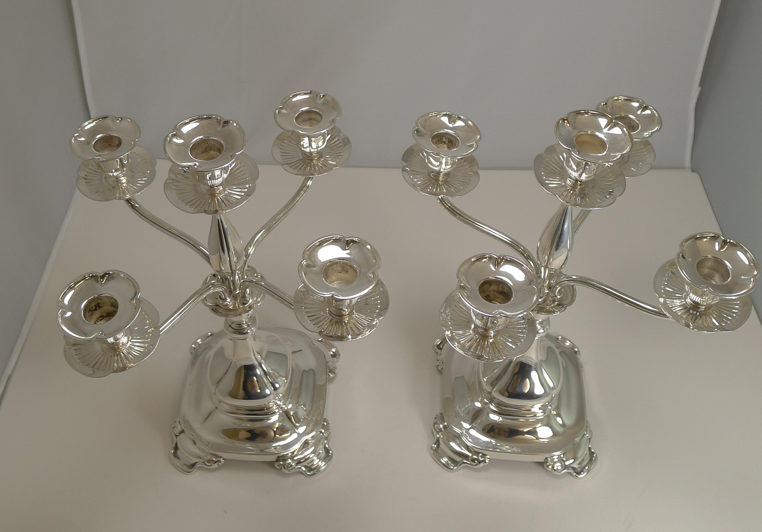 A fabulous pair of American Tiffany candelabra with an Art Nouveau desigh with the four organic feet to each square base and the elegantly shaped central light.

Both the removable sconces and drip trays have a naturalistic floral form

The