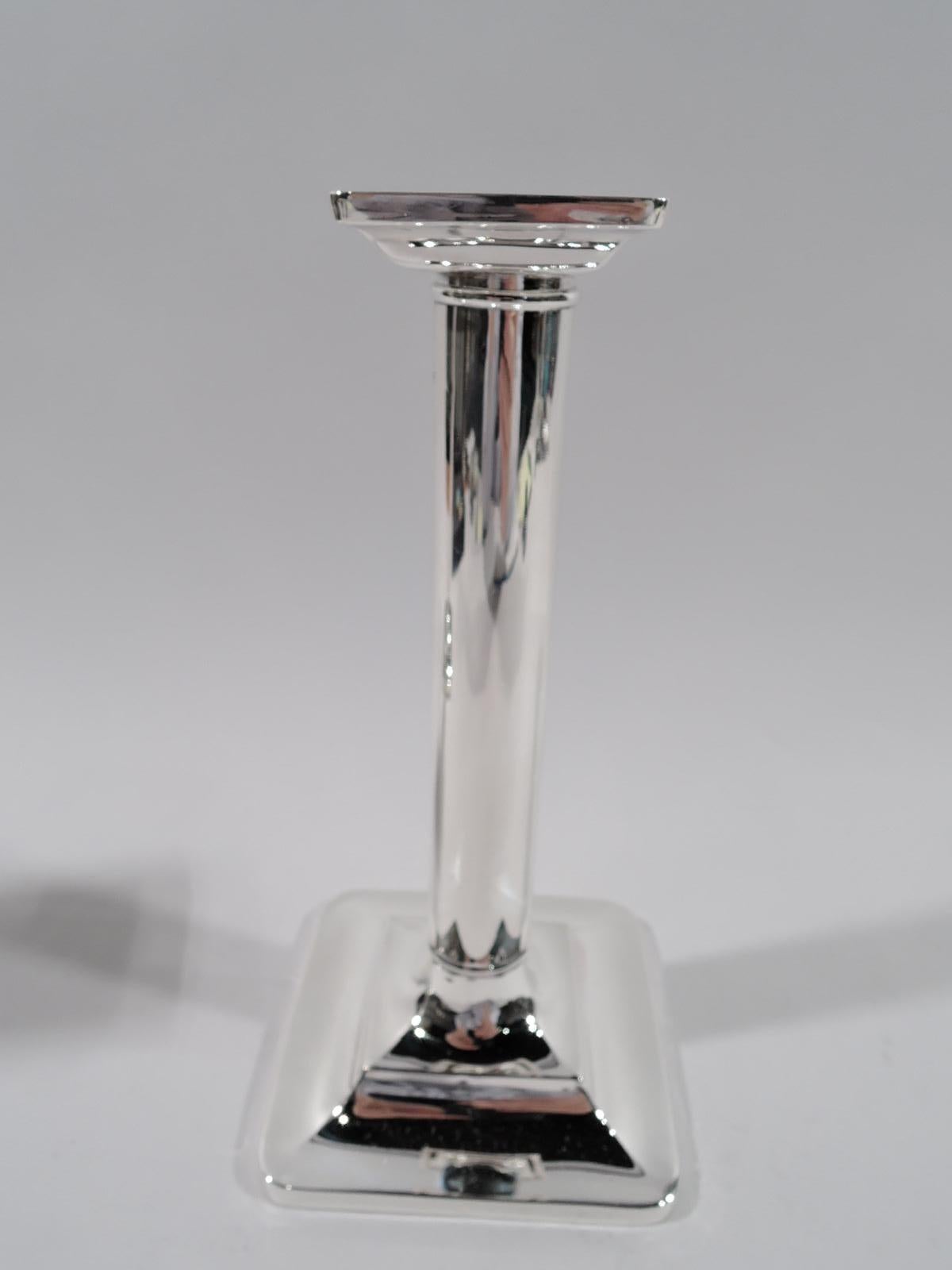 Pair of sterling silver candlesticks. Made by Tiffany & Co. in New York, circa 1910. Column shaft with knop at base; foot square and stepped; bobeche square and detachable. Spare Classicism. Fully marked including pattern no. 15893, order no. 2435,