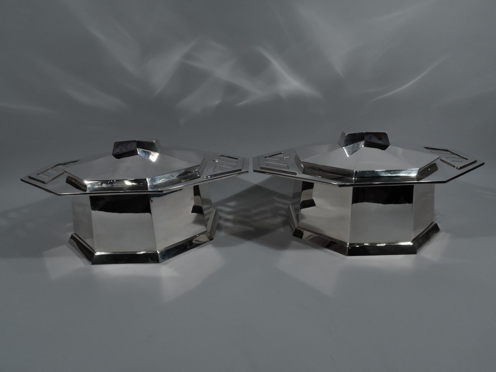 Pair of sterling silver covered tureens after a design by Frank Lloyd Wright. Retailed by Tiffany & Co. in New York. Each: Octagonal bowl and wide and overhanging rim with applied and cutout Modern fretwork handles. Spread base. Raised cover with