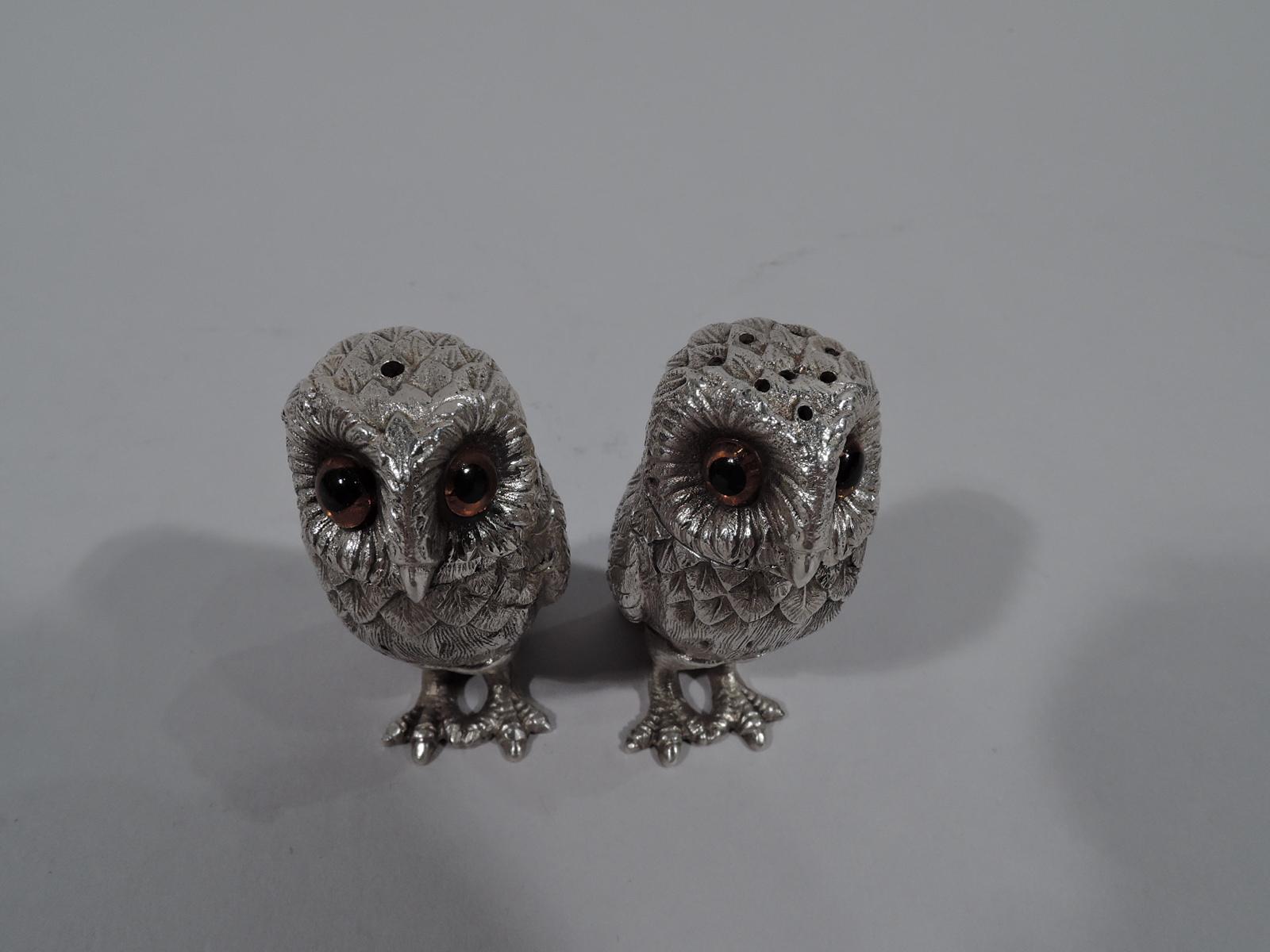 Traditional sterling silver figural owl salt and pepper shakers. Made by Tiffany & Co. in England in London in 1971. Each: Erect with tucked-down wings, dense imbricated feathers, and scaly talons. Dark glass eyes that suggest the beady and