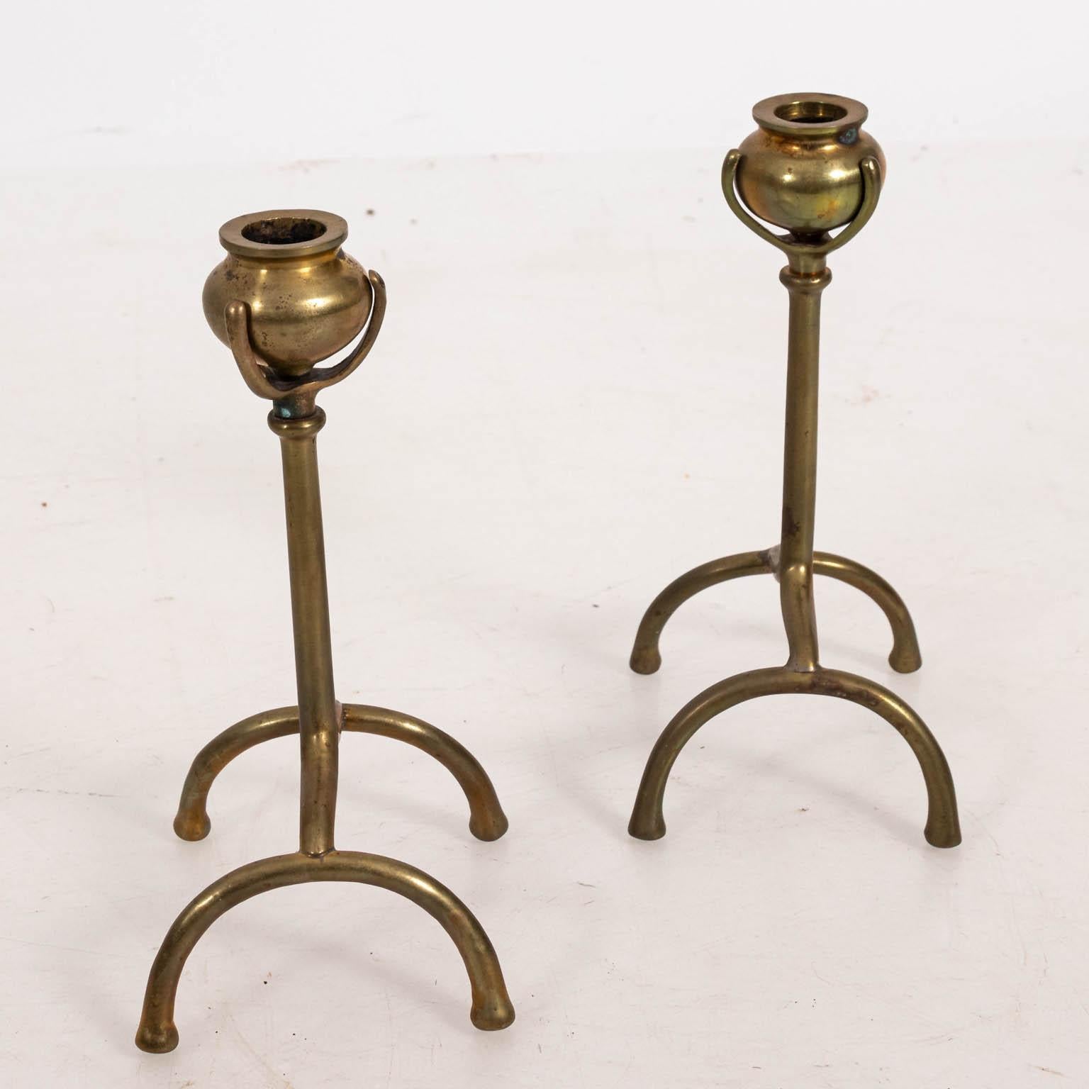 Pair of aesthetic movement style brass poppy stem candlesticks in the manner of Tiffany & Co., circa 20th century. Please note of wear consistent with age including minor tarnishing and oxidation. Made in the United States.