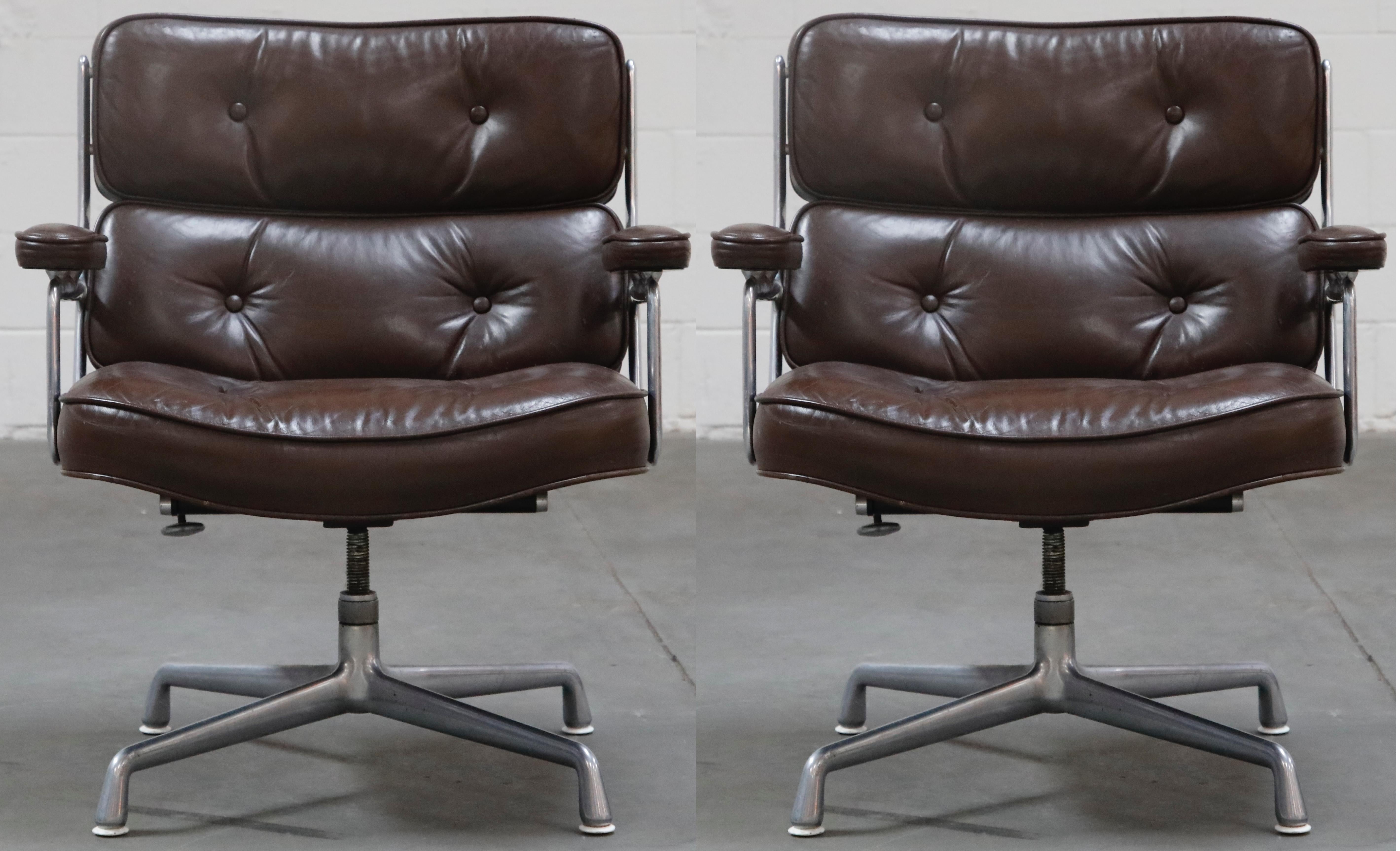 This wonderful pair of Time Life 'Lobby' lounge swivel armchairs were designed by Charles Eames in 1959 and manufactured by Herman Miller, these examples produced in the 1970s. This handsome pair features its original deep chocolate brown colored