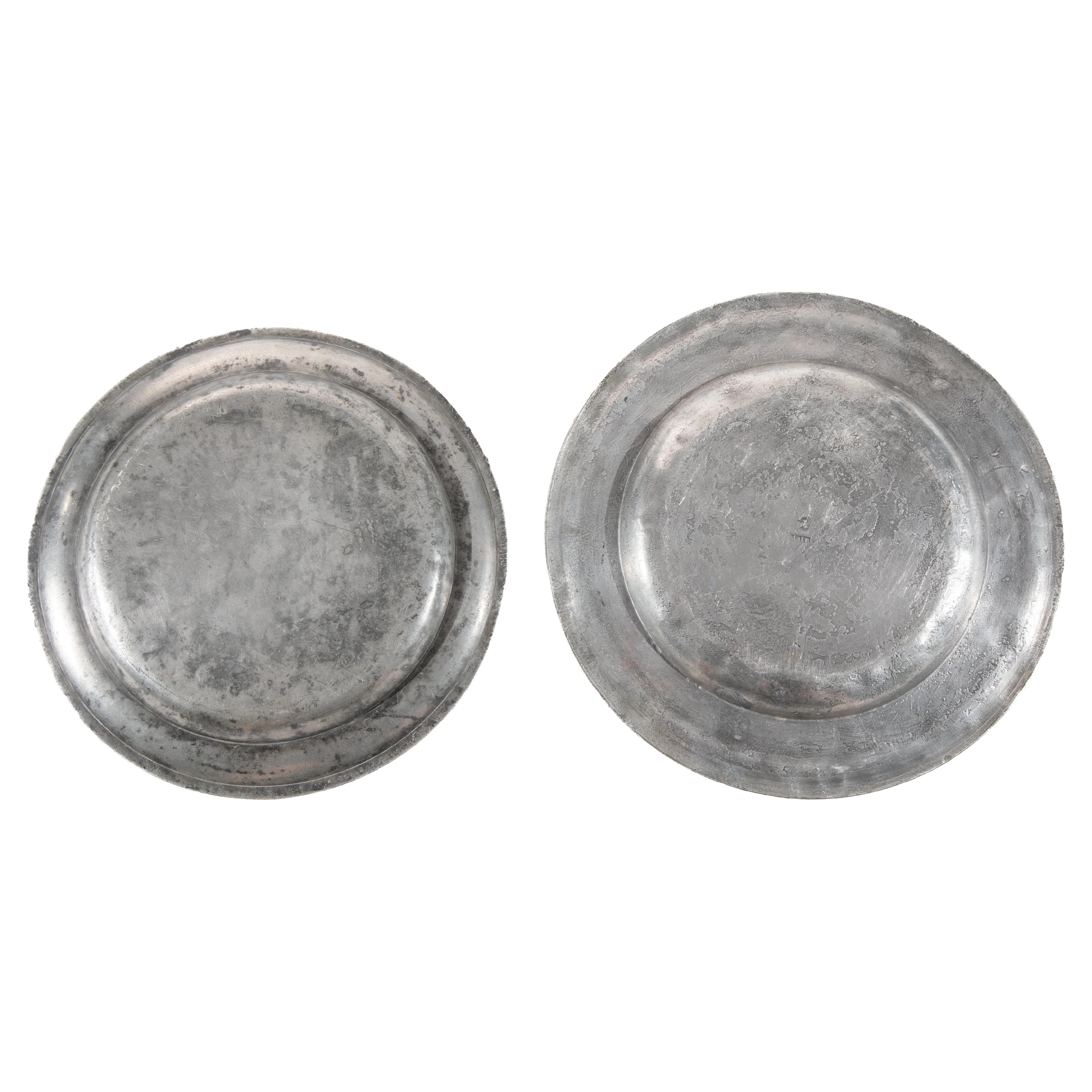 Deux assiettes en étain du 19e siècle.  Lieu d'origine, France.
Le plus grand plat est estampillé d'un écusson au recto et d'un 