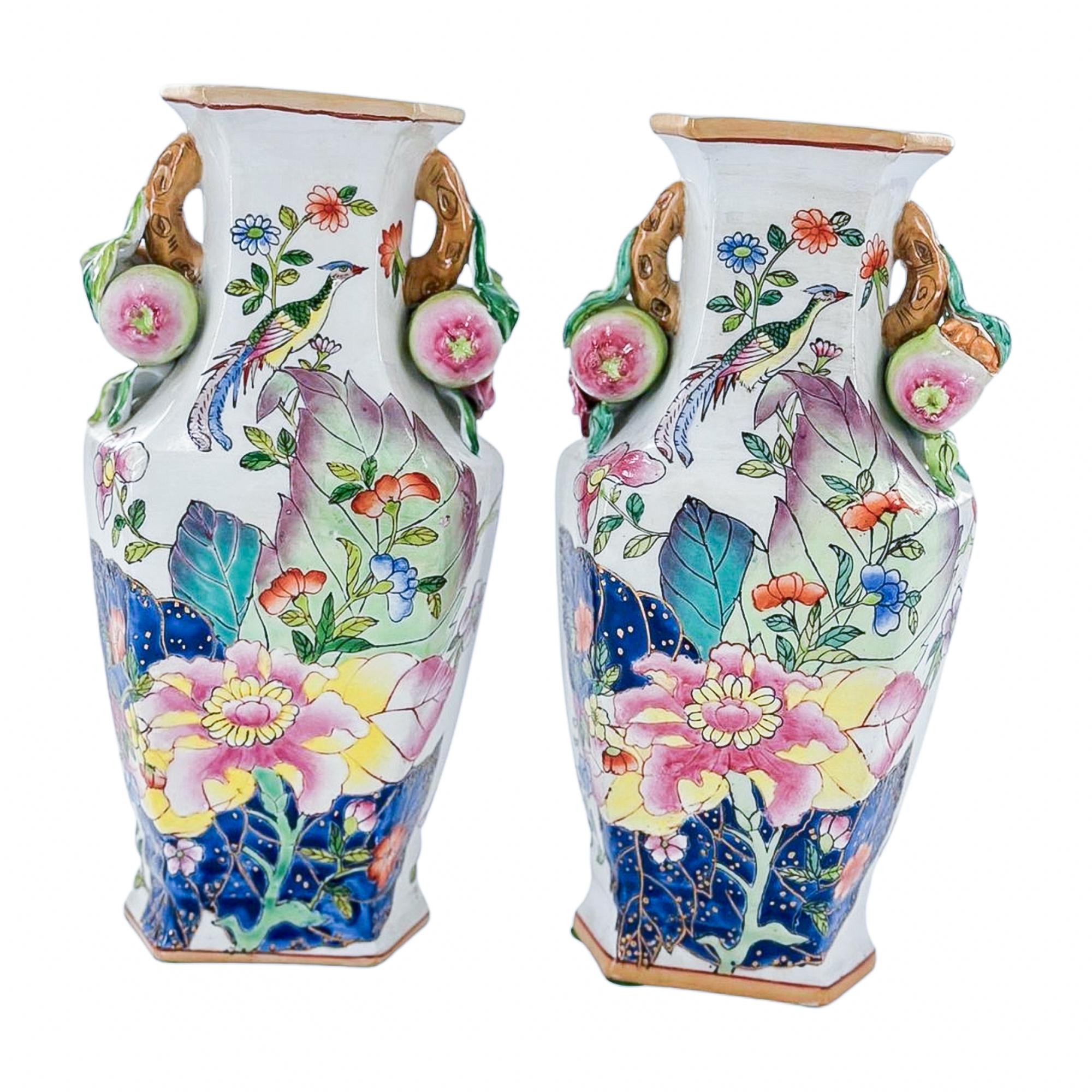 Symmetrical, sculptural, and full of story, this striking pair of vases draws inspiration from the iconic Tobacco Leaf tradition. Painterly florals in saturated tones unfold across the surface, accompanied by perched birds and intricate foliage that