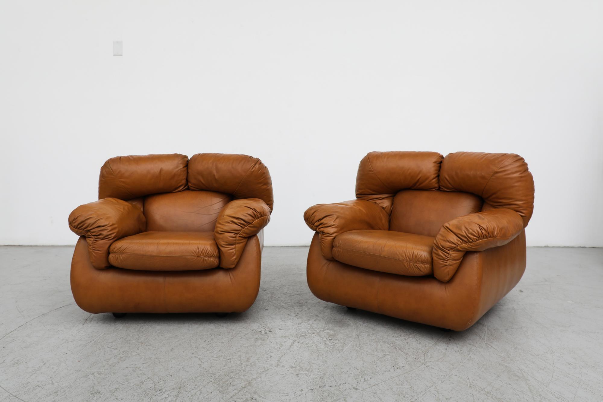 Pair of super comfortable Tobia Scarpa style faux Cognac leather lounge chairs with plush back support and cushioned armrests. In original condition with beautiful faux leather and some wear consistent with their age and use. 
Set price. 