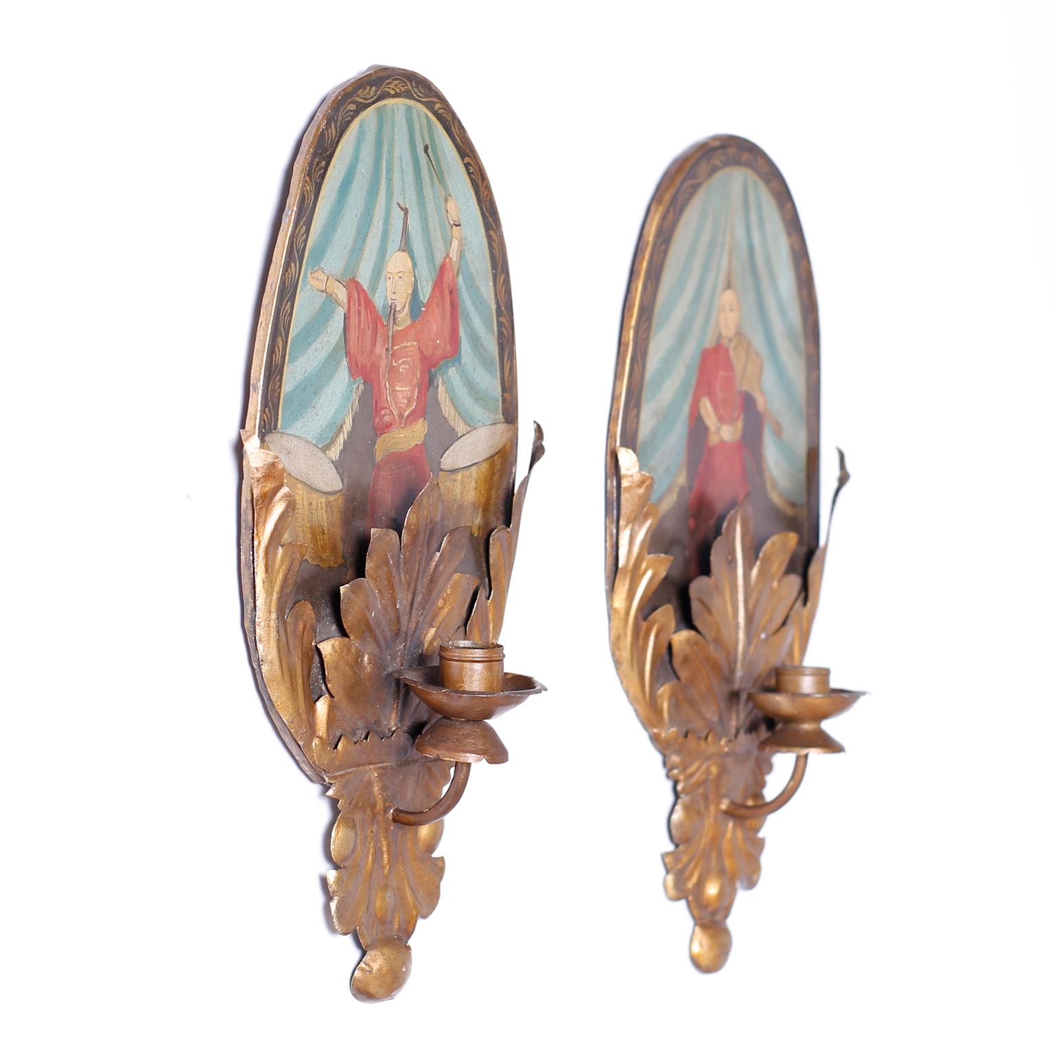 Pair of antique one light wall sconces with hand painted chinoiserie tole plaques over gilt metal acanthus leaves and metal candle cups. An interesting history is revealed on the back of one.