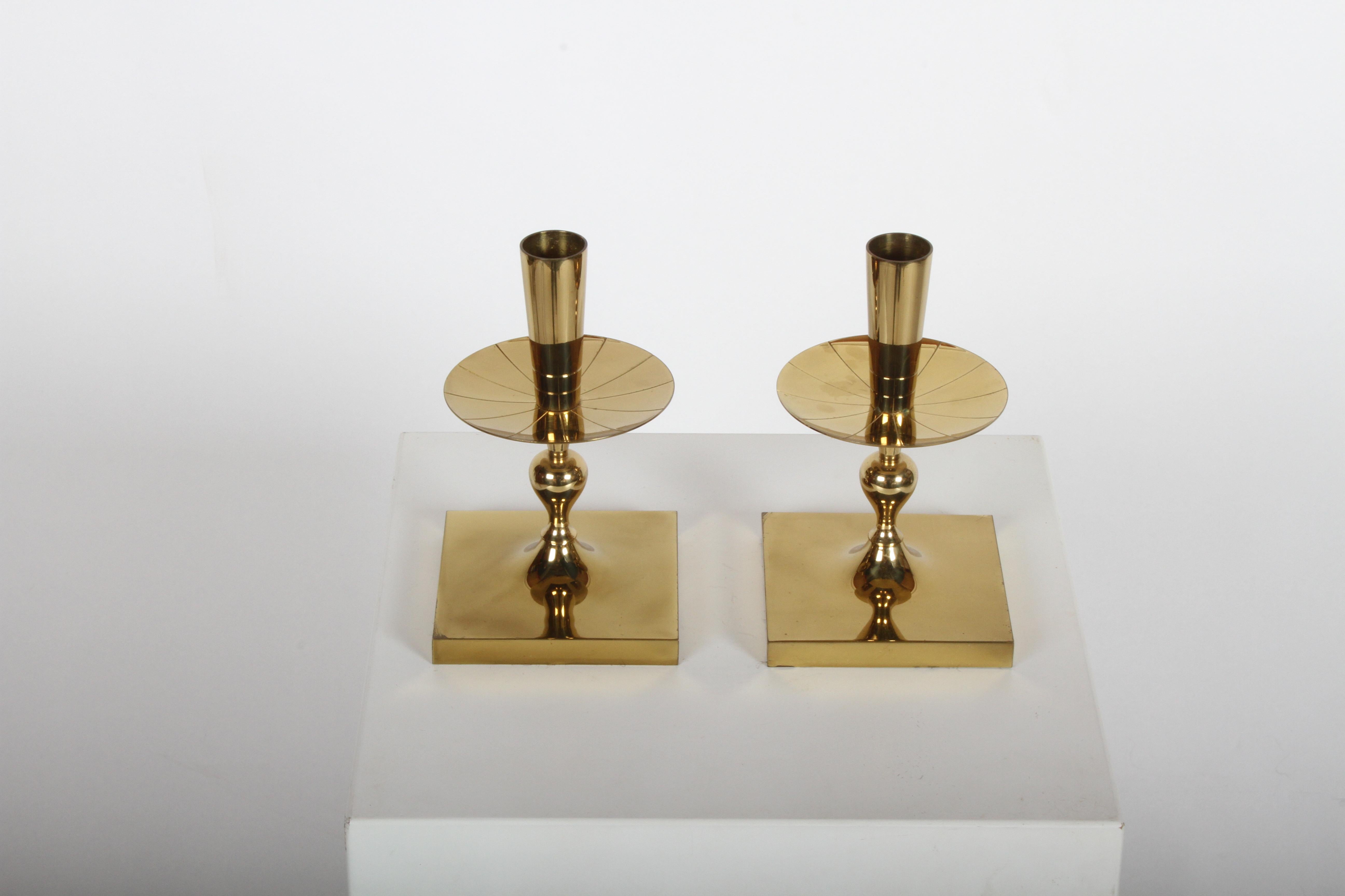 Pair of Tommi Parzinger brass candleholders, made by Dorlyn-Silversmiths, circa 1950s. Candleholders appear to have little or no use. Branded made by Dorlyn-Silversmiths. Minor patina.
