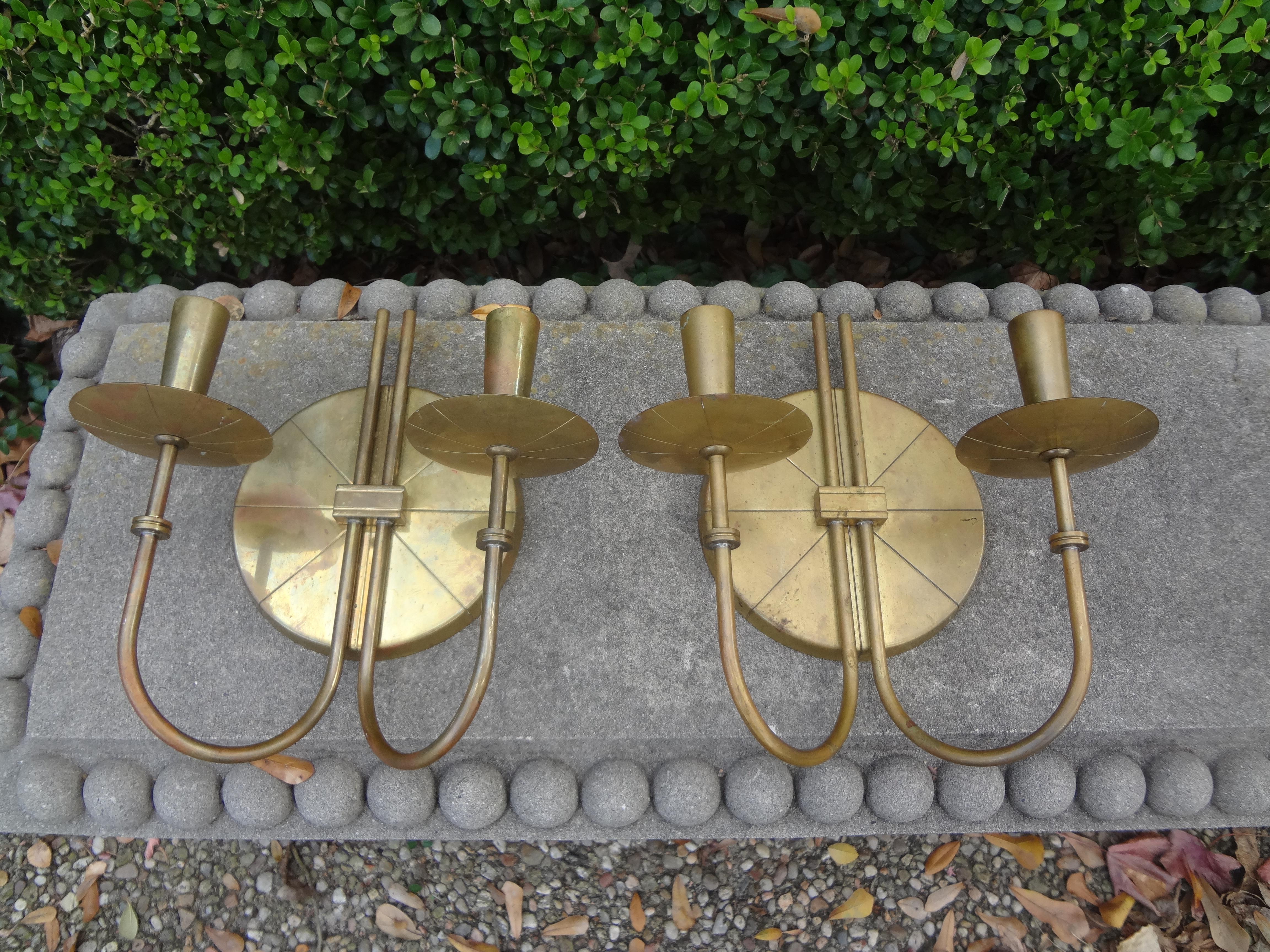 Fantastic pair of Mid-Century Modern brass sconces by Tommi Parzinger. These stunning modernist brass two-light sconces with geometric etched circular back plate were never electrified. Can be used with candles as originally designed or easily