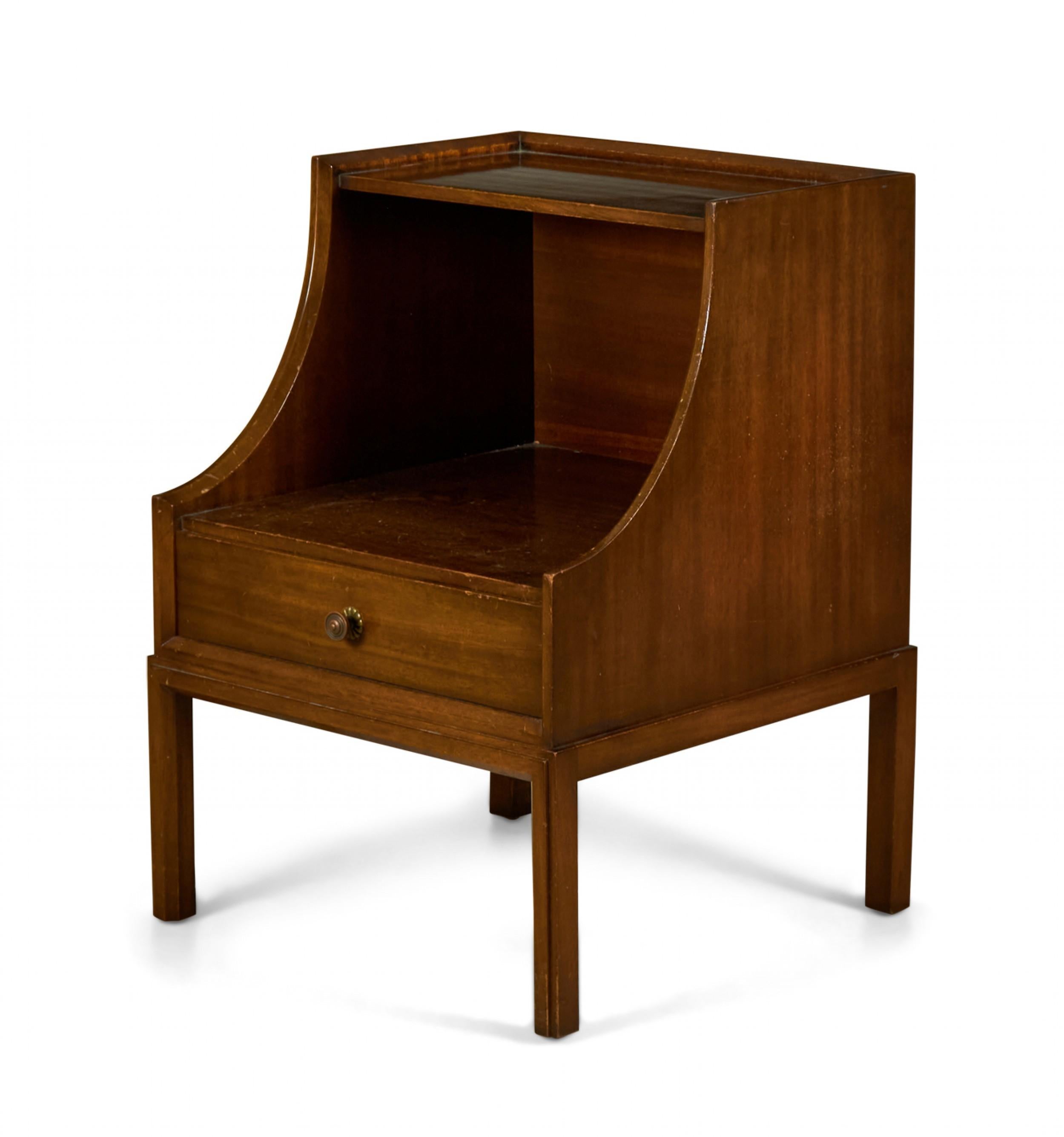 Pair of American mid-century walnut bedside tables / nightstands with a single drawer under a scoop front open compartment with upper shelf resting on four dowel legs. (Tommi Parzinger)(Priced as Pair).
   