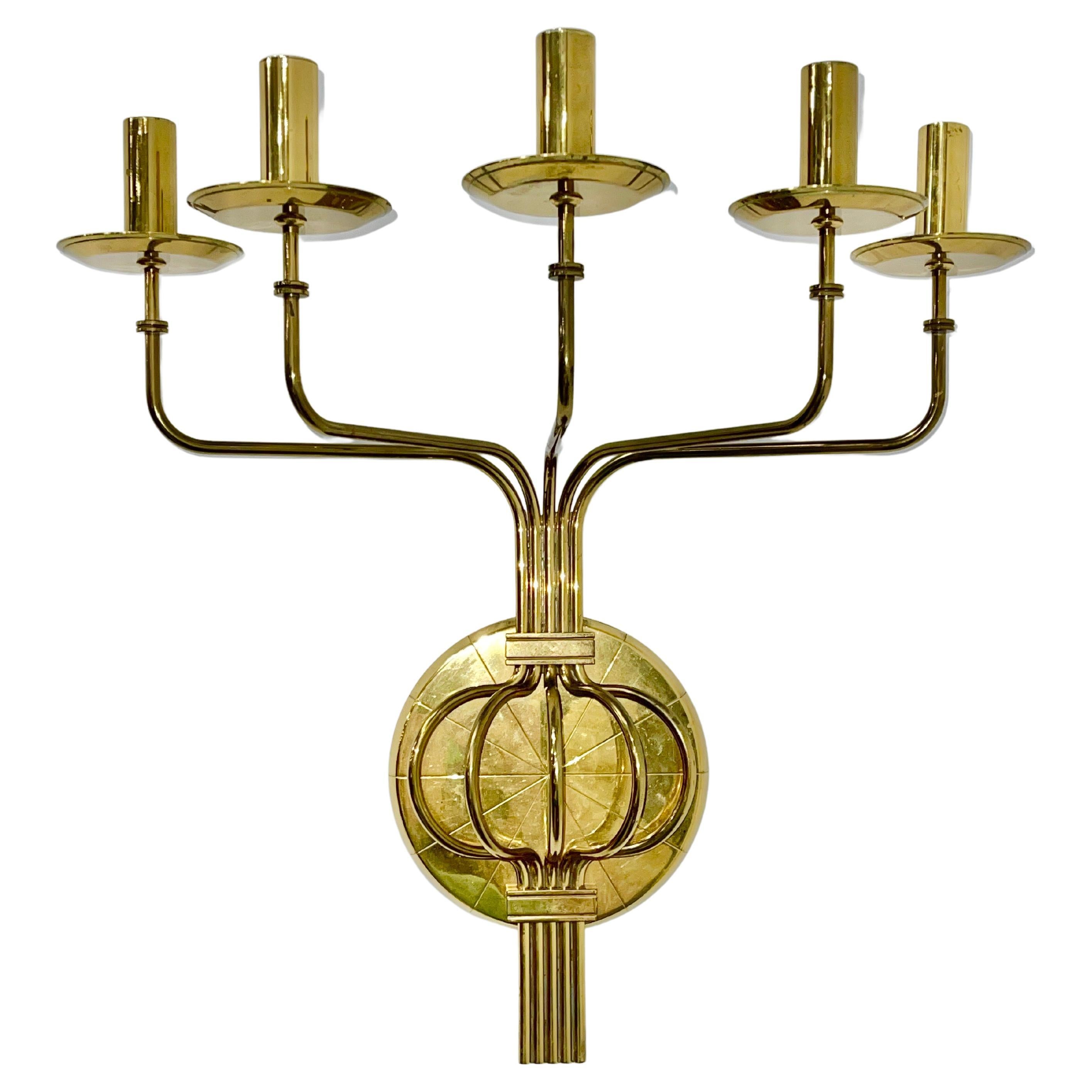 Pair of solid brass five arm candle sconces designed by Tommi Parzinger and produced by Dorlyn Silversmiths. 
No. 106 in the Dorlyn catalog.
Very heavy gauge solid brass.
Tubular brass candle holders removable for ease of cleaning.
Backplate 7.5