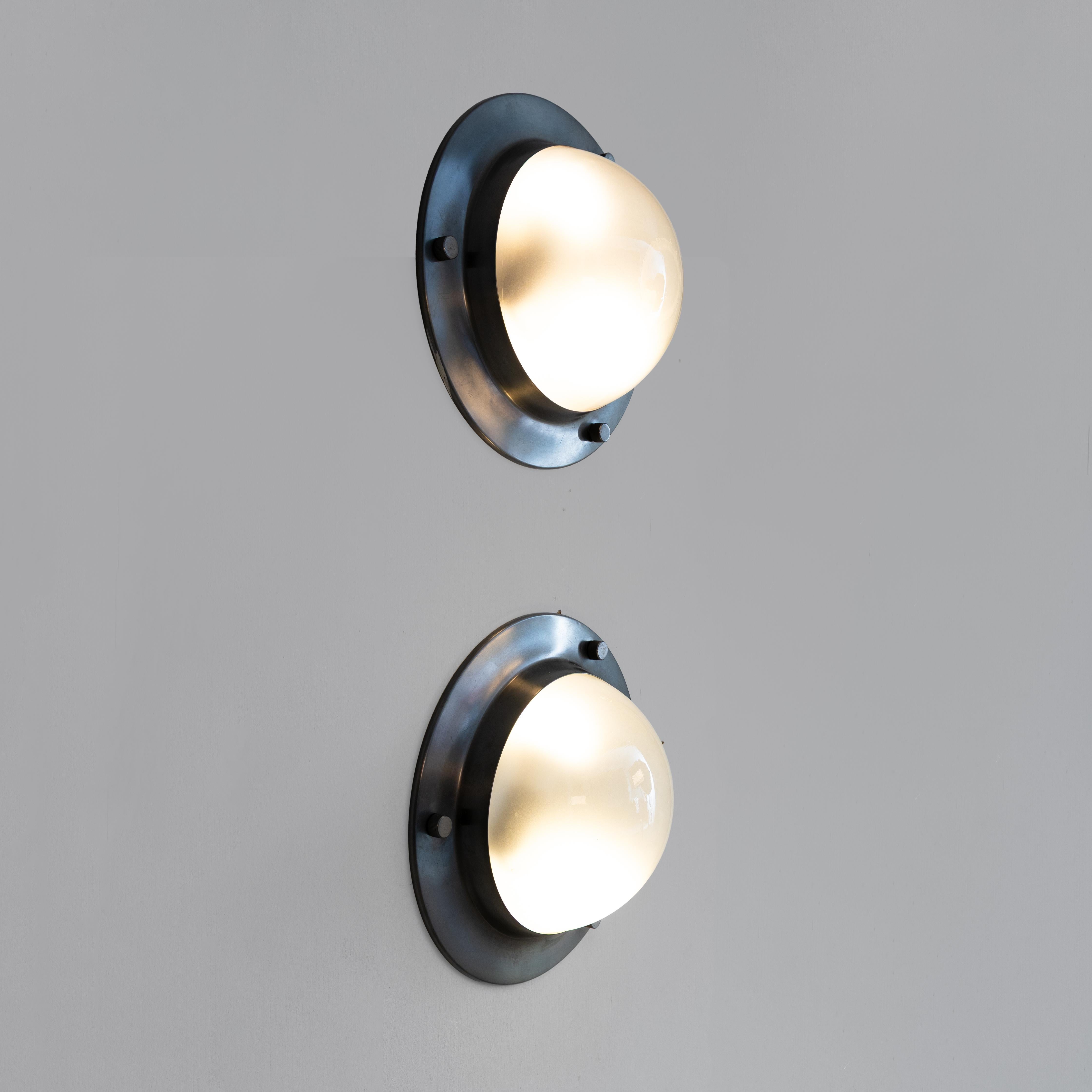 The Pair of Tommy LSP6 lamps, designed by Luigi Caccia Dominioni in Italy circa 1965, stands as a testament to timeless modern design. Crafted with meticulous attention to detail, these lamps showcase Caccia Dominioni's innovative vision and