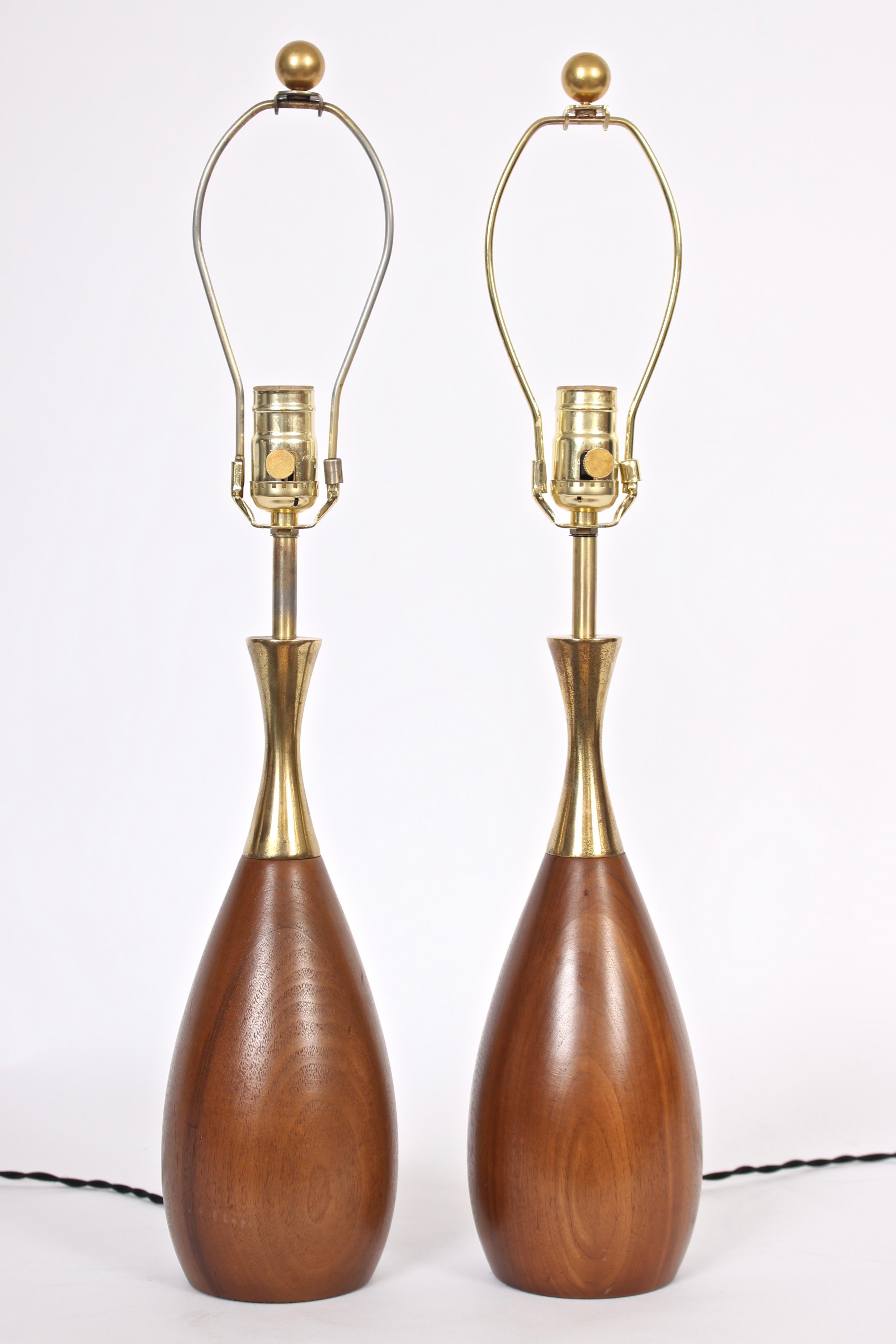 American Mid Century Modern pair of Tony Paul for Westwood Industries solid walnut and brass table lamps, 1950s. Featuring a smooth beautifully grained bowling pin form in solid Walnut accented with reflective flared brass upper. 18 H to top of