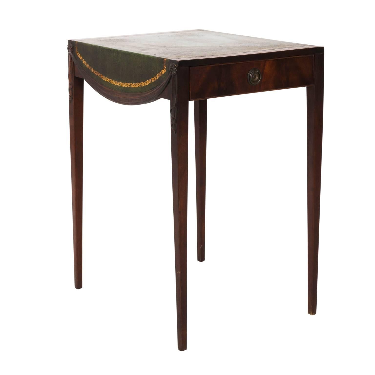 Pair of green tooled leather top side table by the Eckhardt-Barman Company with Mahogany swag carved trim draping the sides and square tapered legs, circa 1940. This piece also features embossed foliage detail on the leather top.