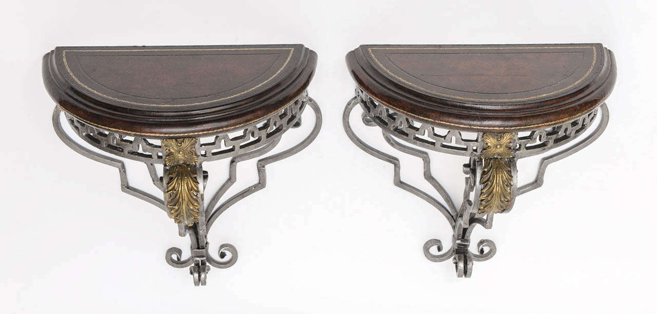 Great pair of neoclassical steel and brass wall brackets with dark brown tooled leather tops.