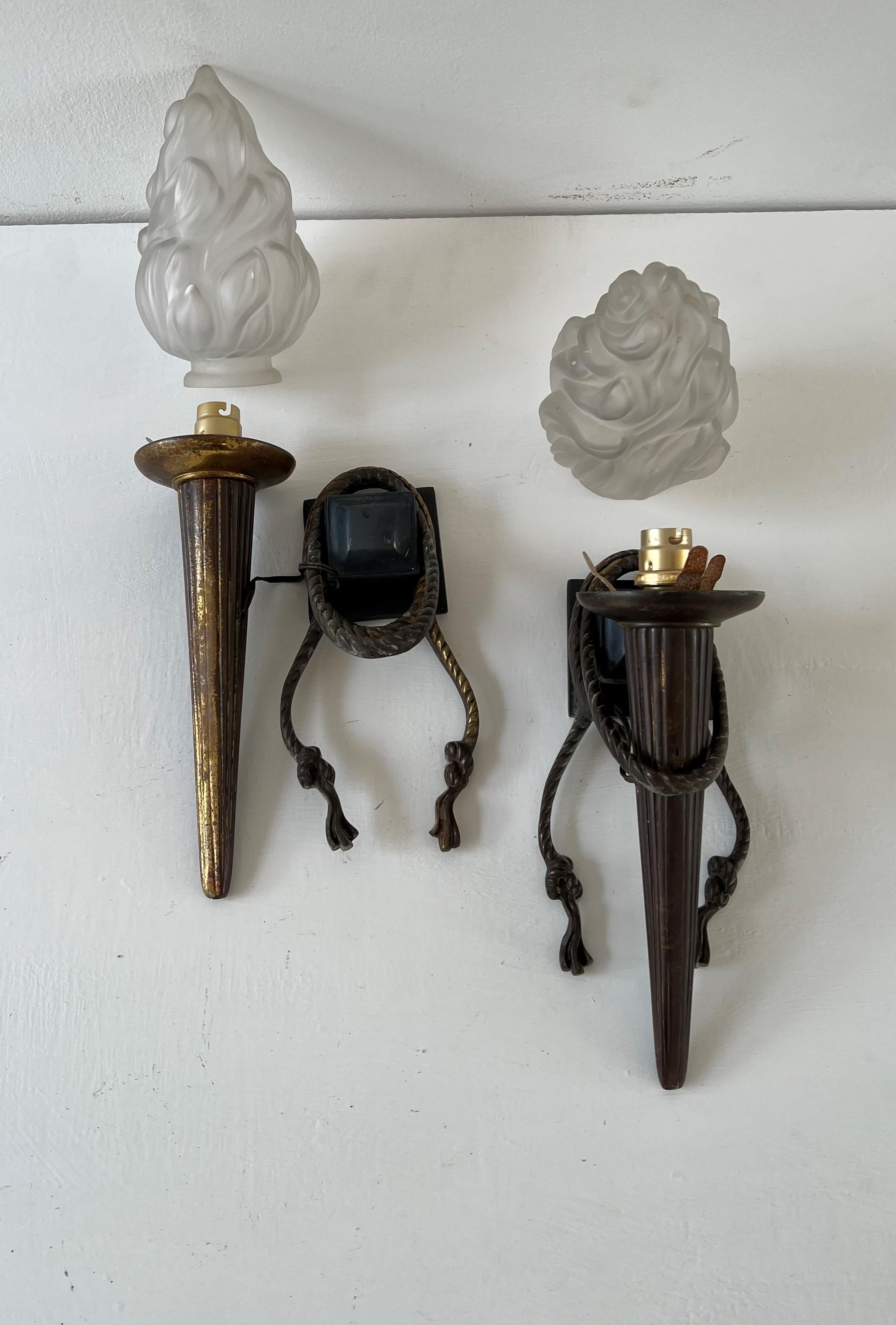 Very nice pair of sconces manufactured in heavy bronze and with pressed glass lamp shades depicting Torches.
These hold bayonet bulbs but can be changed for more modern ones easily.
There is some rubbing to the back of one scone which shows the