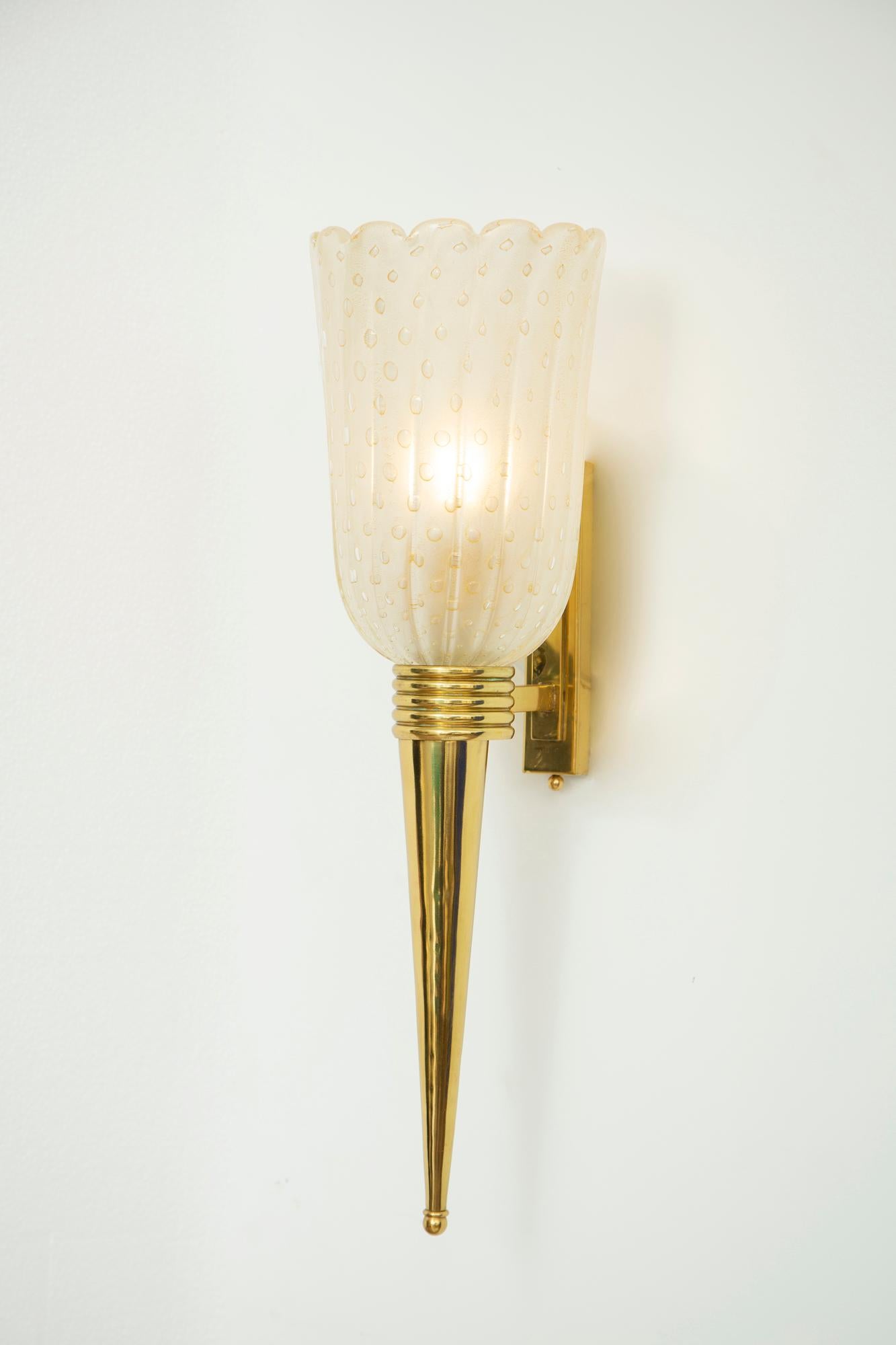 Paire d'appliques torchères en laiton et verre de Murano. Verre soufflé à la main, moucheté d'or, bulles encastrées et laiton poli.
Taille de la douille unique E26.
2 paires disponibles en stock.