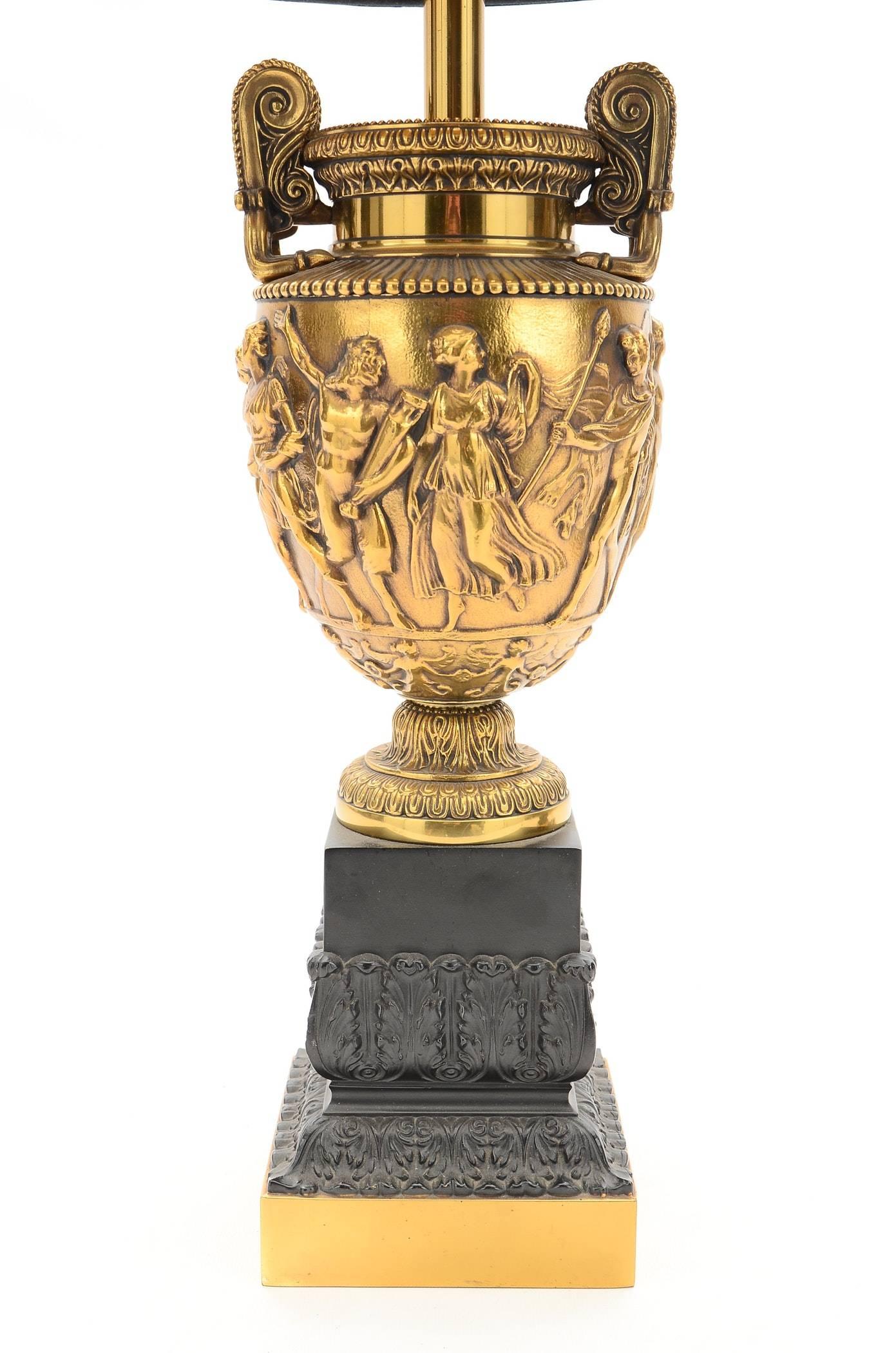 These antiqued brass urn lamps are styled after an ancient Roman vase discovered in 1773, named Townley's vase, kept in British Museum in London. The deep antiqued brass and black finish enhances the rich sculpting details. Stamped with Stiffel.