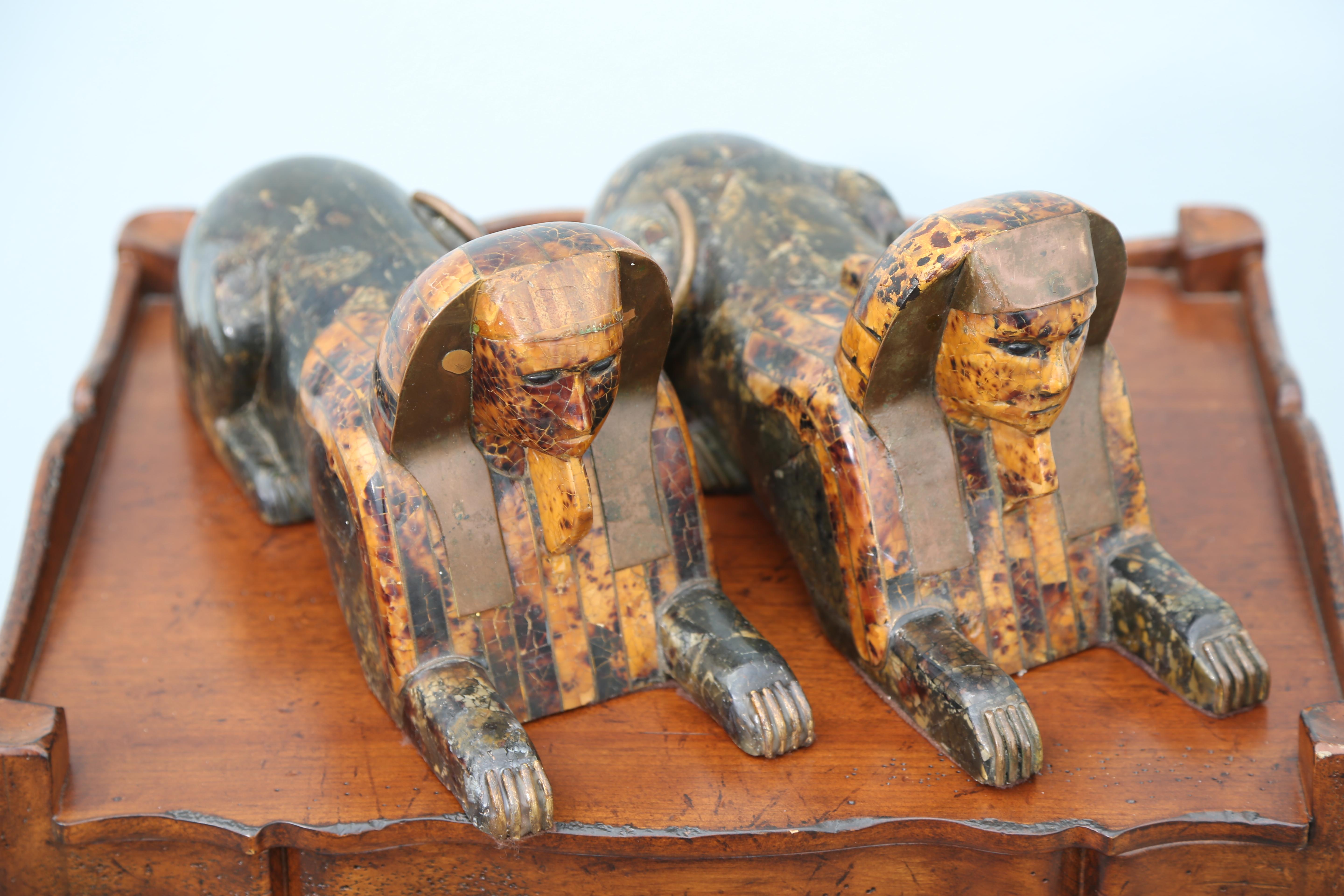Pair of reclining sphinx's with tortoise and brass inlay's by Anthony Redmile.