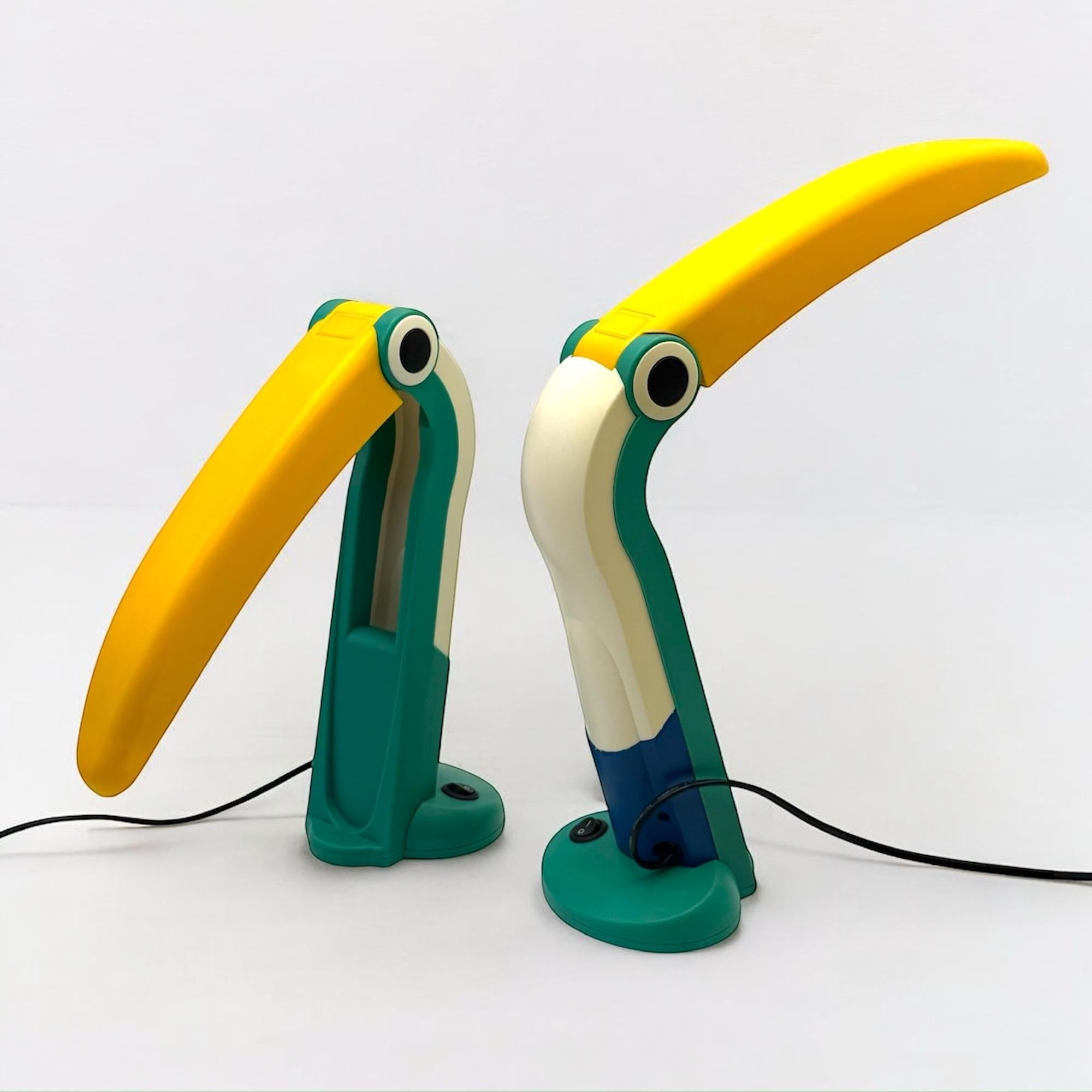 Paire de lampes de bureau Huangslite Toucan, un design emblématique des années 1990-2000. Design/One et fabriquées à Whiting, ces lampes présentent une silhouette ludique inspirée des toucans, avec un abat-jour pliable à bec jaune et un corps vert