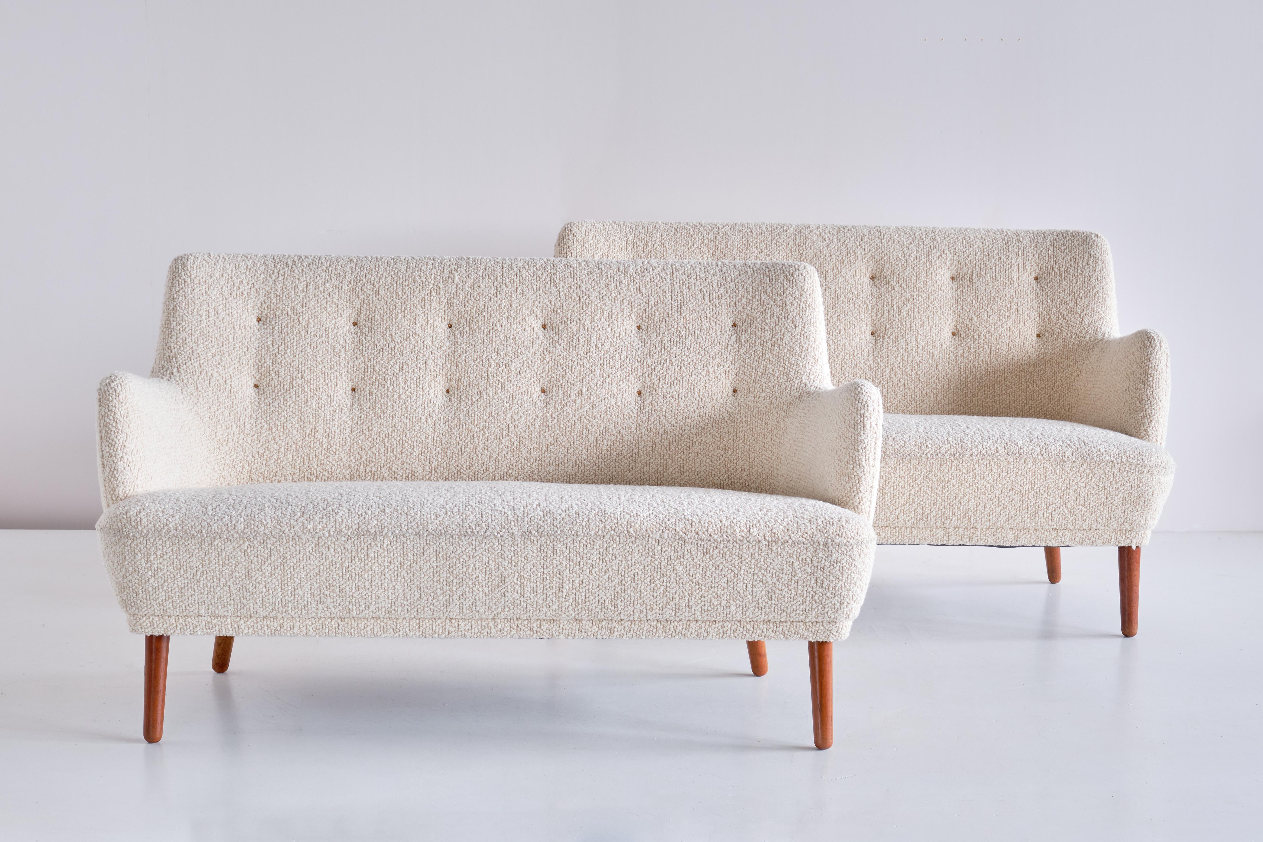 This exceptionally rare two seater sofa was designed by Tove & Edvard Kindt-Larsen and produced by the master cabinet maker Gustav Bertelsen in the early 1950s. The sofa has been newly upholstered in an ivory white wool bouclé fabric with a buttoned