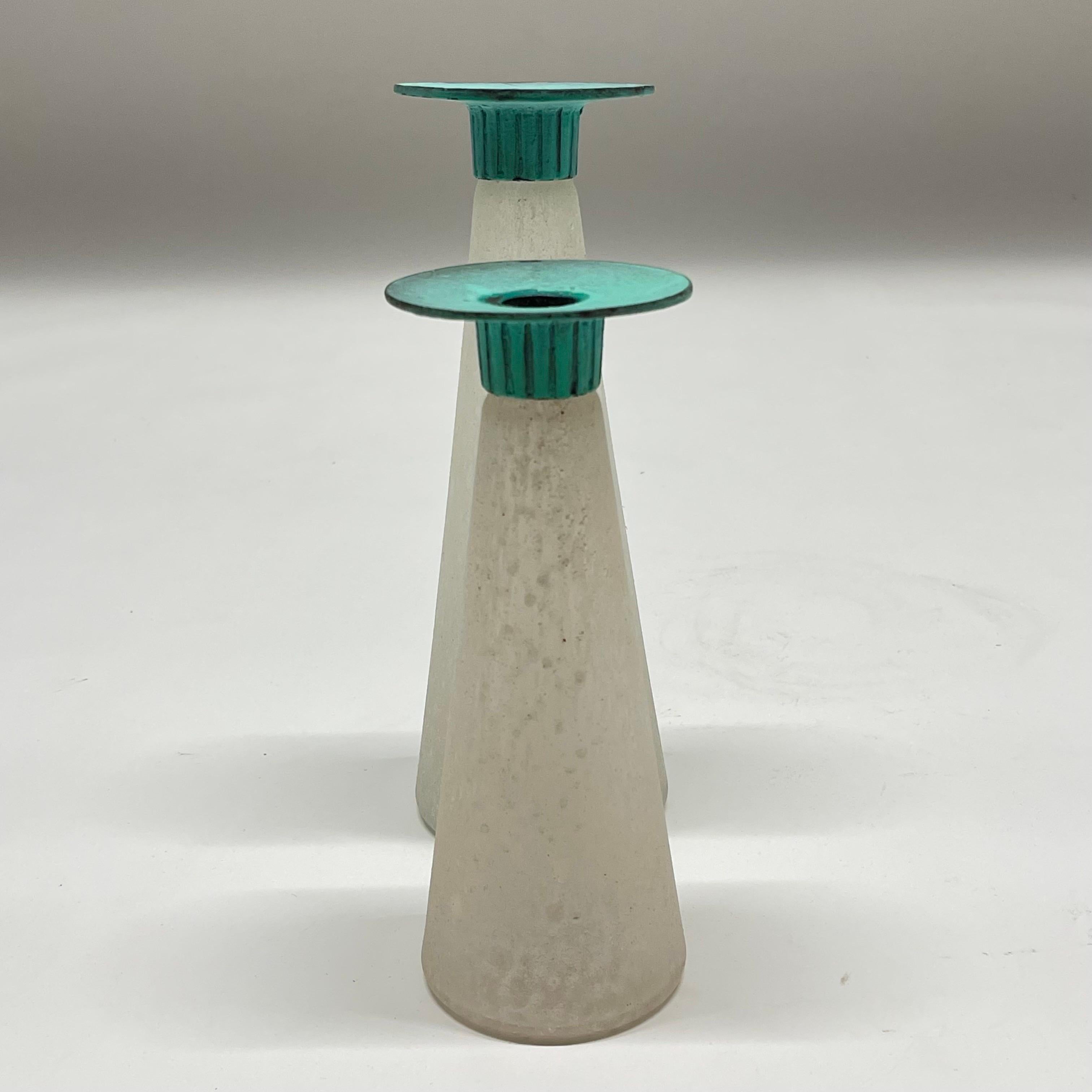 Post Modern pair of asymmetrical candlesticks or candle holders, rendered in scavo corroso glass conical bases with verdigris patinated bronze candle cups, by Toyo, made in Taiwan, circa 1980s.