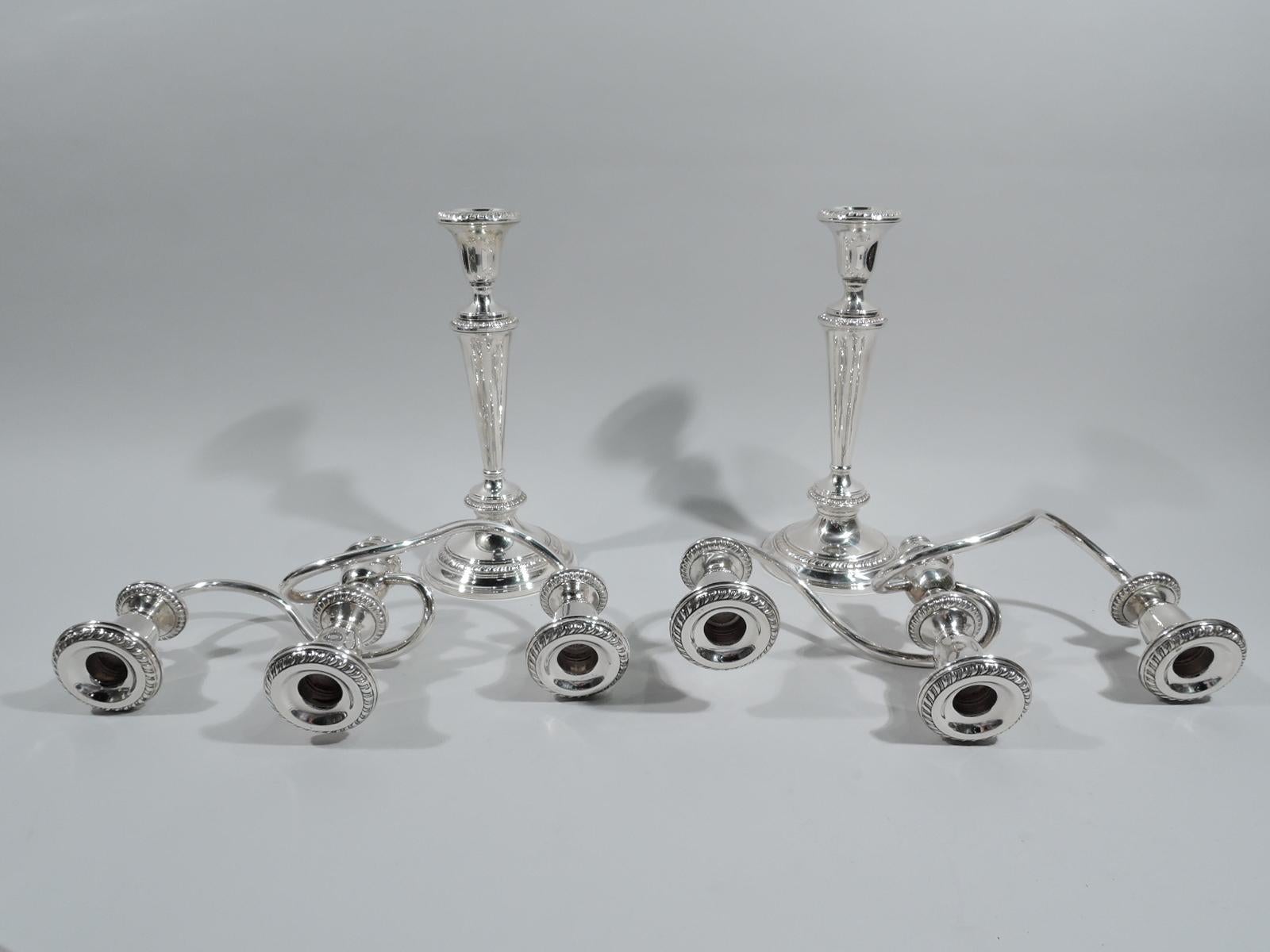 Pair of American sterling silver 3-light candelabra. Each: tapering and knopped shaft on domed foot. Urn sconce supporting 2 arms each terminating in single socket and wrapping around central raised socket. Converts to candlestick. Gadrooning. Fully