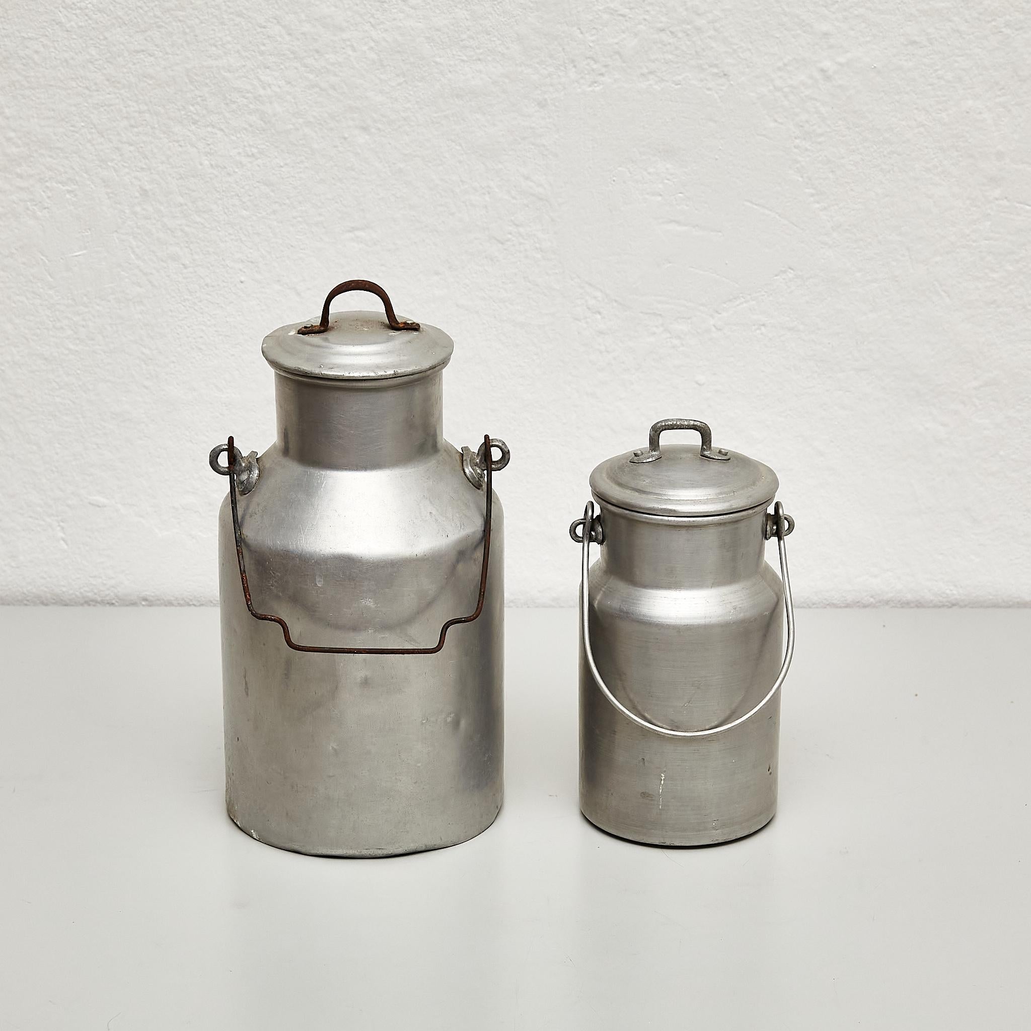 Pair of Vintage metal lidded milk pots with a handle.

By unknown manufacturer, made in Spain, circa 1950.

In original condition, with minor wear consistent with age and use, preserving a beautiful patina.

Materials:
Metal.