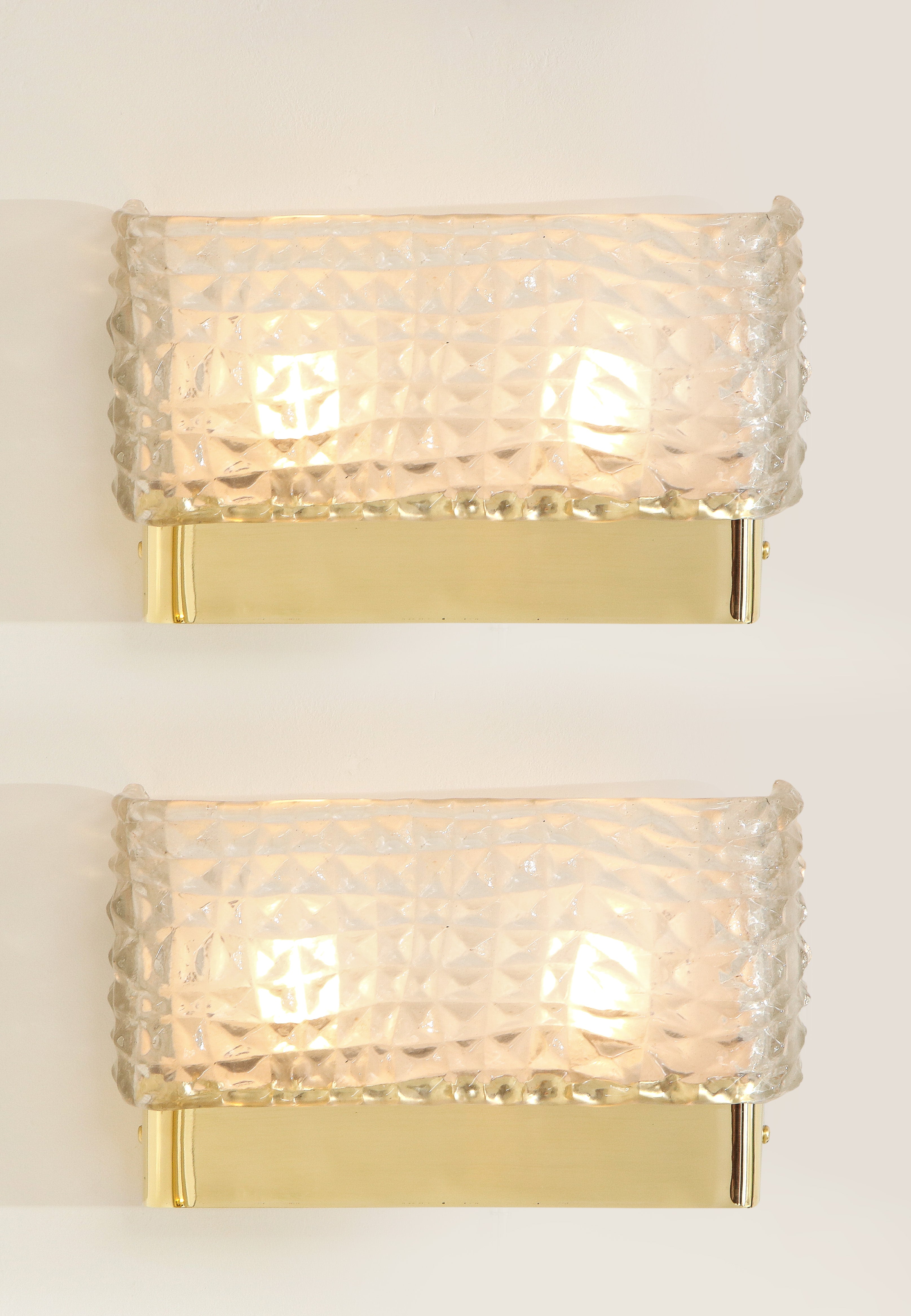 Pair of clear Murano textured glass and brass rectangular sconces handmade in Italy, 2022. Hand-casted translucent and textured clear white Murano Glass rectangular shade is mounted on a simple brass base. Solid brass caps hold the glass shade in