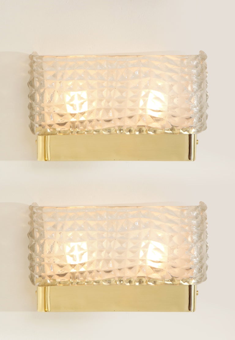 Pair of translucent textured Murano glass and brass rectangular sconces handmade in Italy, 2022. Hand-casted translucent and textured clear white Murano Glass rectangular shade is mounted on a simple brass base. Solid brass caps hold the glass shade