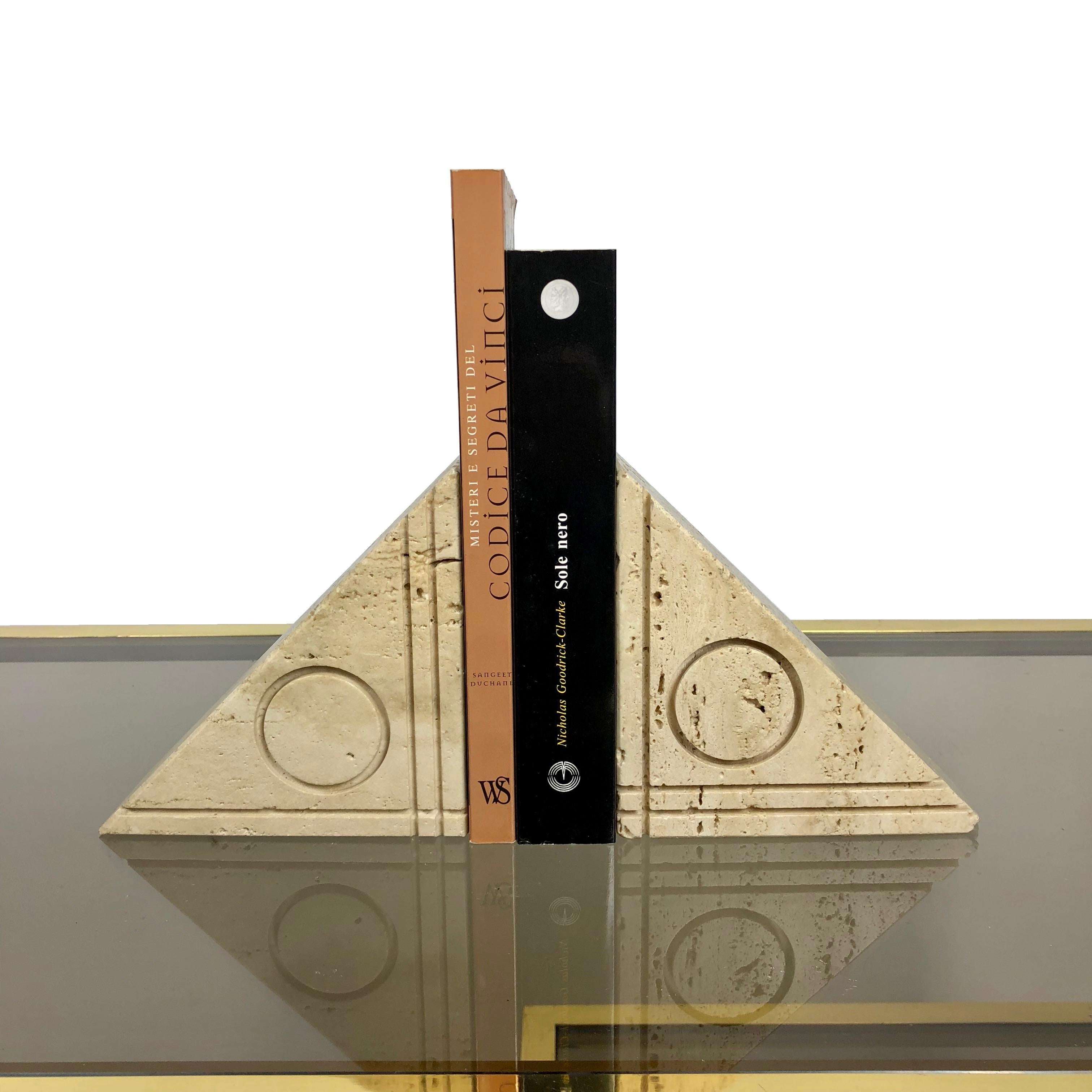Pair of triangular bookends in the style of the Italian designer Angelo Mangiarotti in real travertine. A circle and three lines that intersect to form a right angle are engraved on both of the items.