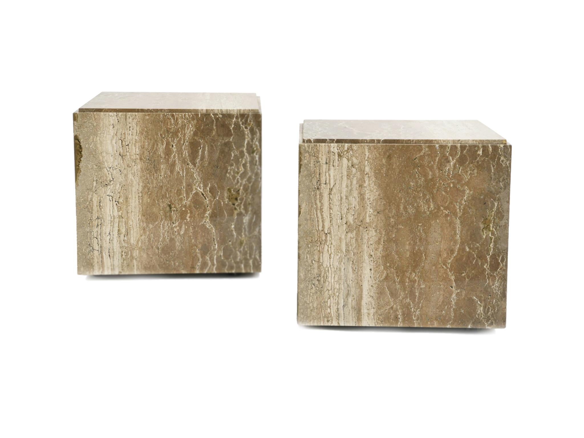 1970s pair of cube side tables comprised of travertine and set on casters. The tables are designed in the style of photographer-designer Willy Rizzo. Like his designs, these tables are geometric forms with smooth, simple lines. We love their