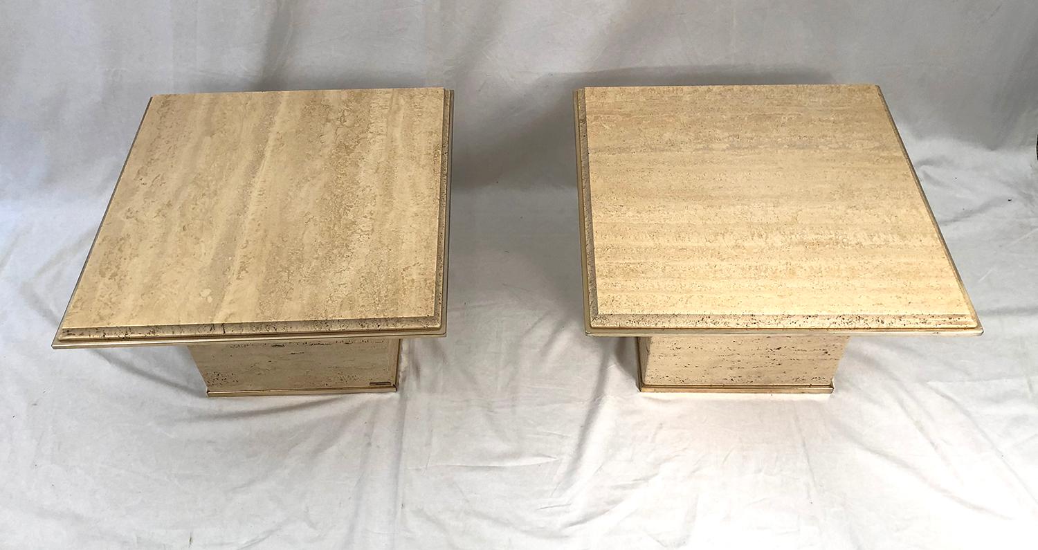 Beautiful pair of travertine sofa end tables adorned with brass belt, manufactured by Fedam, Belgium, 1970s. There is a knock in the travertine tray of one of the two tables.

Magnifique paire de bout de canapé en travertin orné de ceinture en