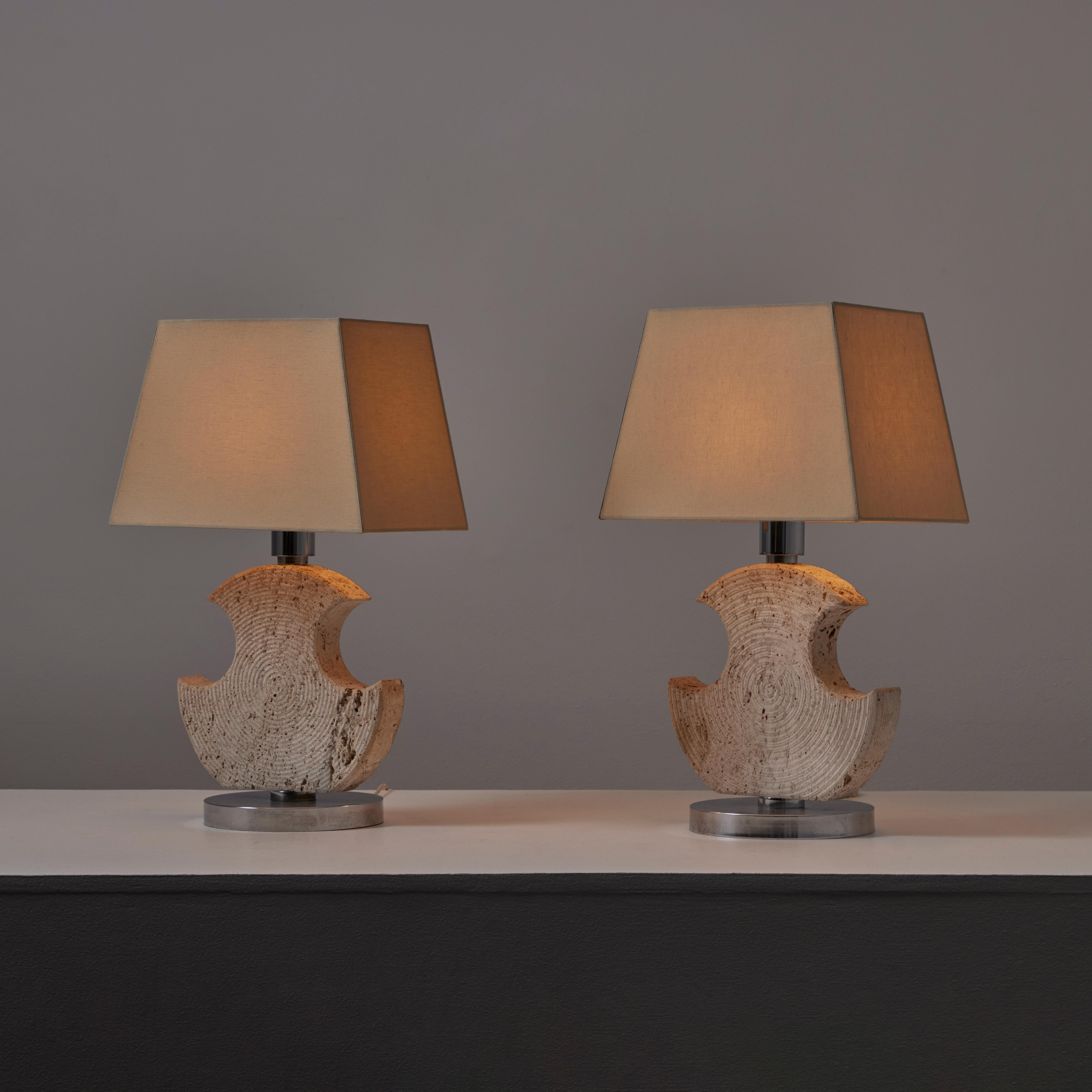 Ein Paar Tischlampen aus Travertin von Studio CE. VA Mailand. Entworfen und hergestellt in Italien, um 1970. Skulpturale und geschnitzte Tischlampen aus Travertin, mit verchromten runden Sockeln und beigen Leinenschirmen. Jede Lampe fasst eine