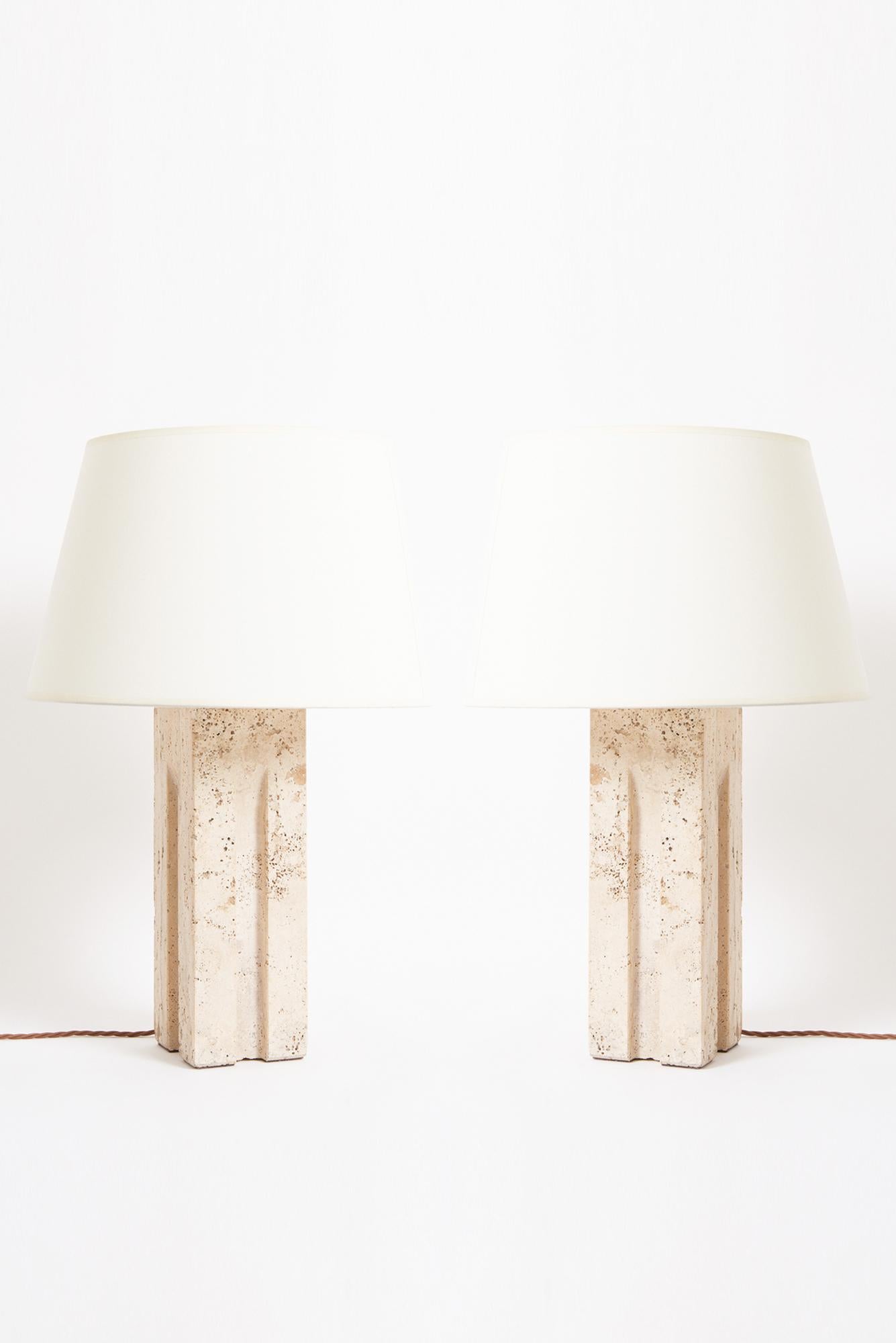 A pair of large carved travertine table lamps
Italy, 1970s
With the shade: 62 cm high by 41 cm diameter 
Lamp base only: 43.5 cm high by 12 cm wide by 12 cm depth