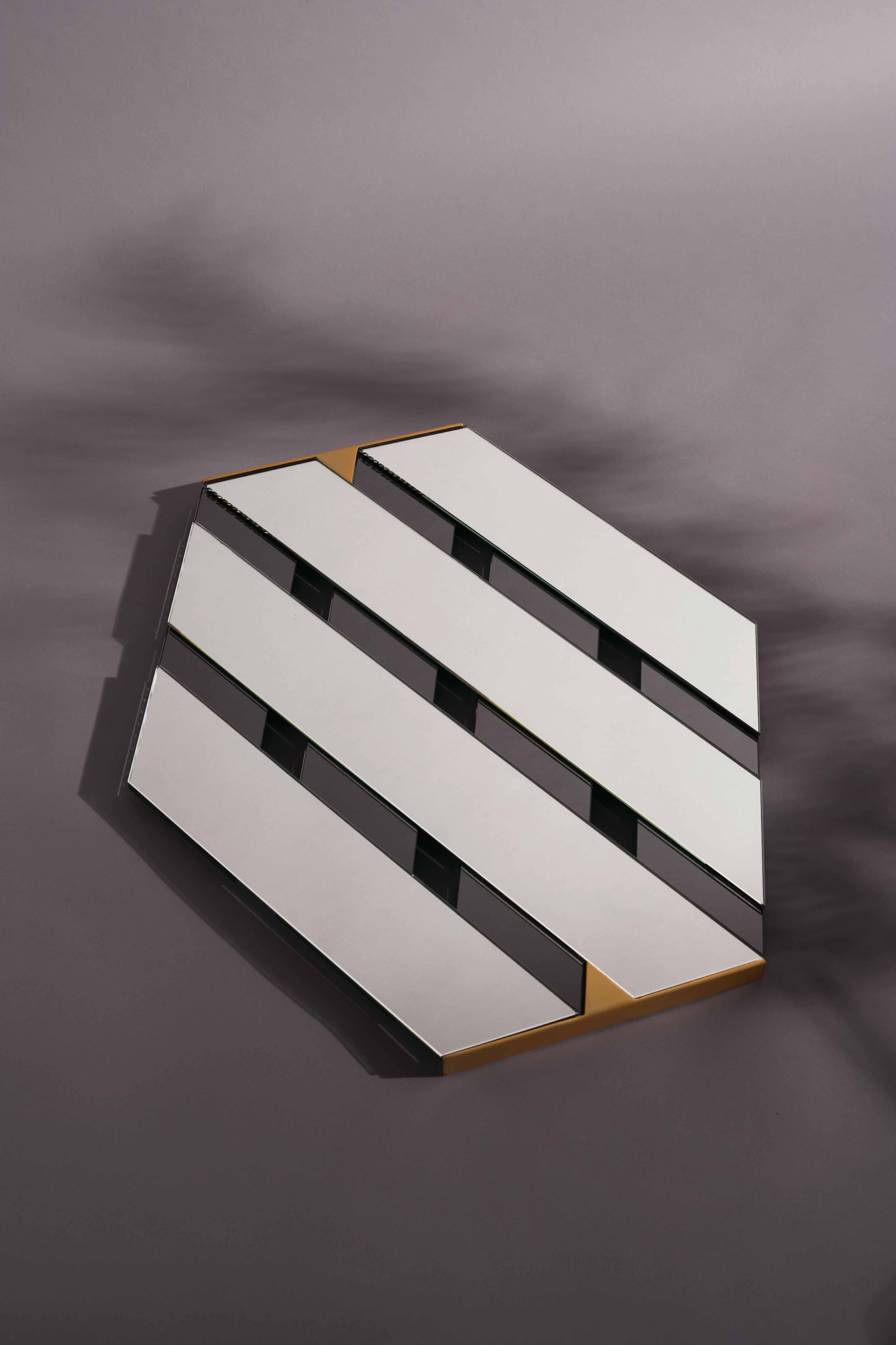 Pair of Tresse mirrors by Mason Editions
Dimensions: 15 x 15 x 31 cm
Materials: Glass and metal

Diagonal bands of reflecting surface, which overlap in an elegant optical effect with as many bands of colored mirror: this hexagonal mirror recalls