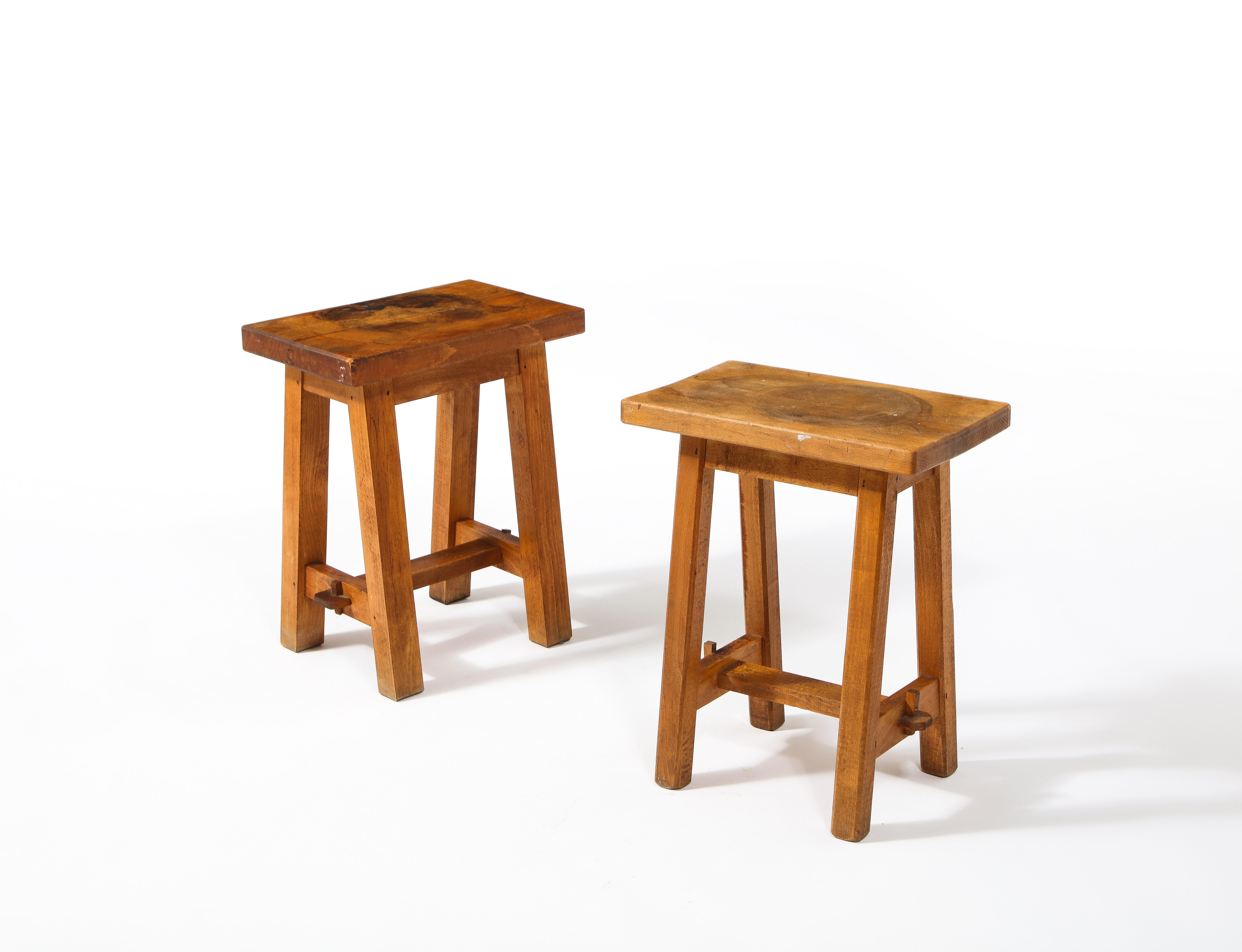 A pair of trestle walnut stools in original finish.