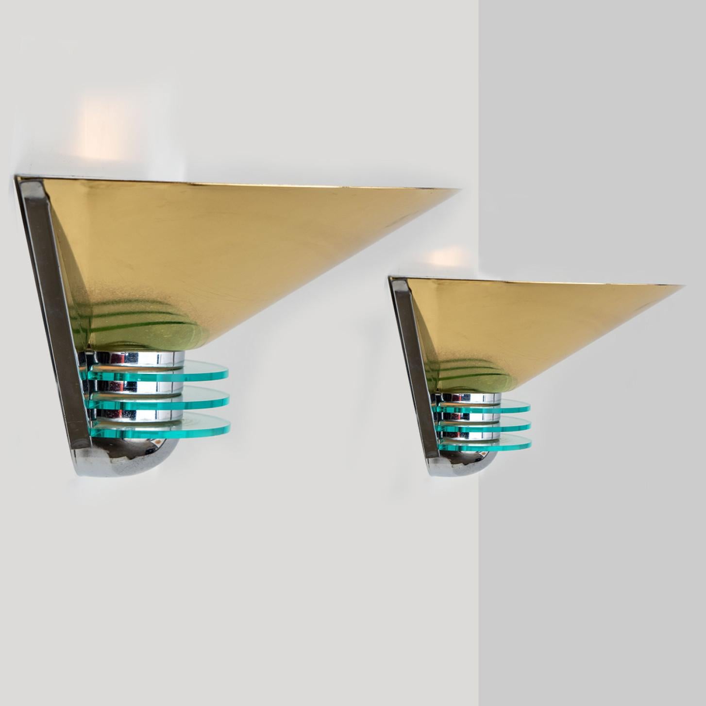 Triangle shaped wall lights in brass and chrome with glass details. Manufactured in Germany during the 1980s.
Nice craftsmanship. Minimal, geometric and simply shaped design.

Please note the price is for a pair. We have one set