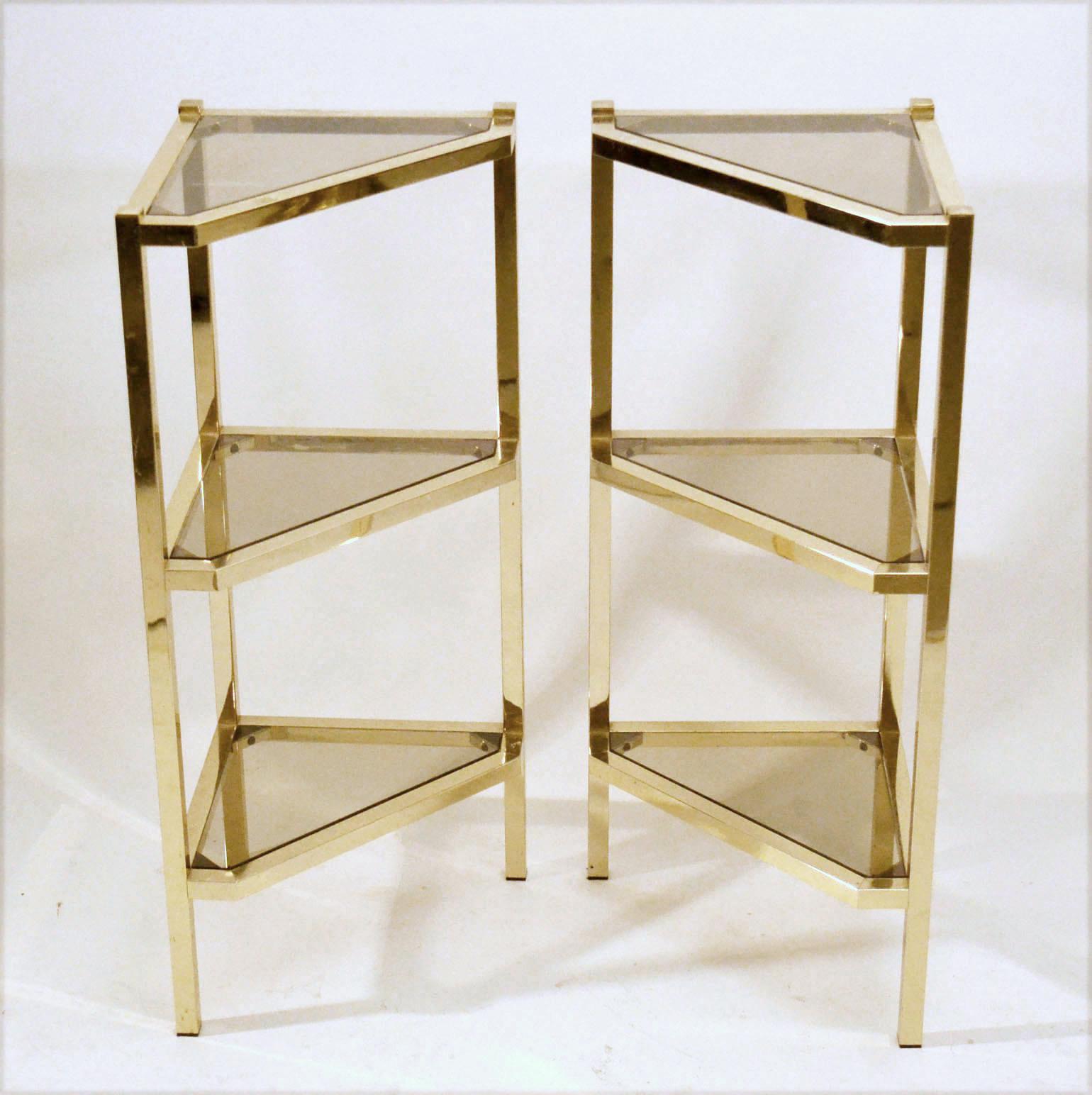 Pair of 1970s Hollywood Regency style of triangular shelving units in brass with tinted glass shelves for display of decorative objects. are very versatile in placing.