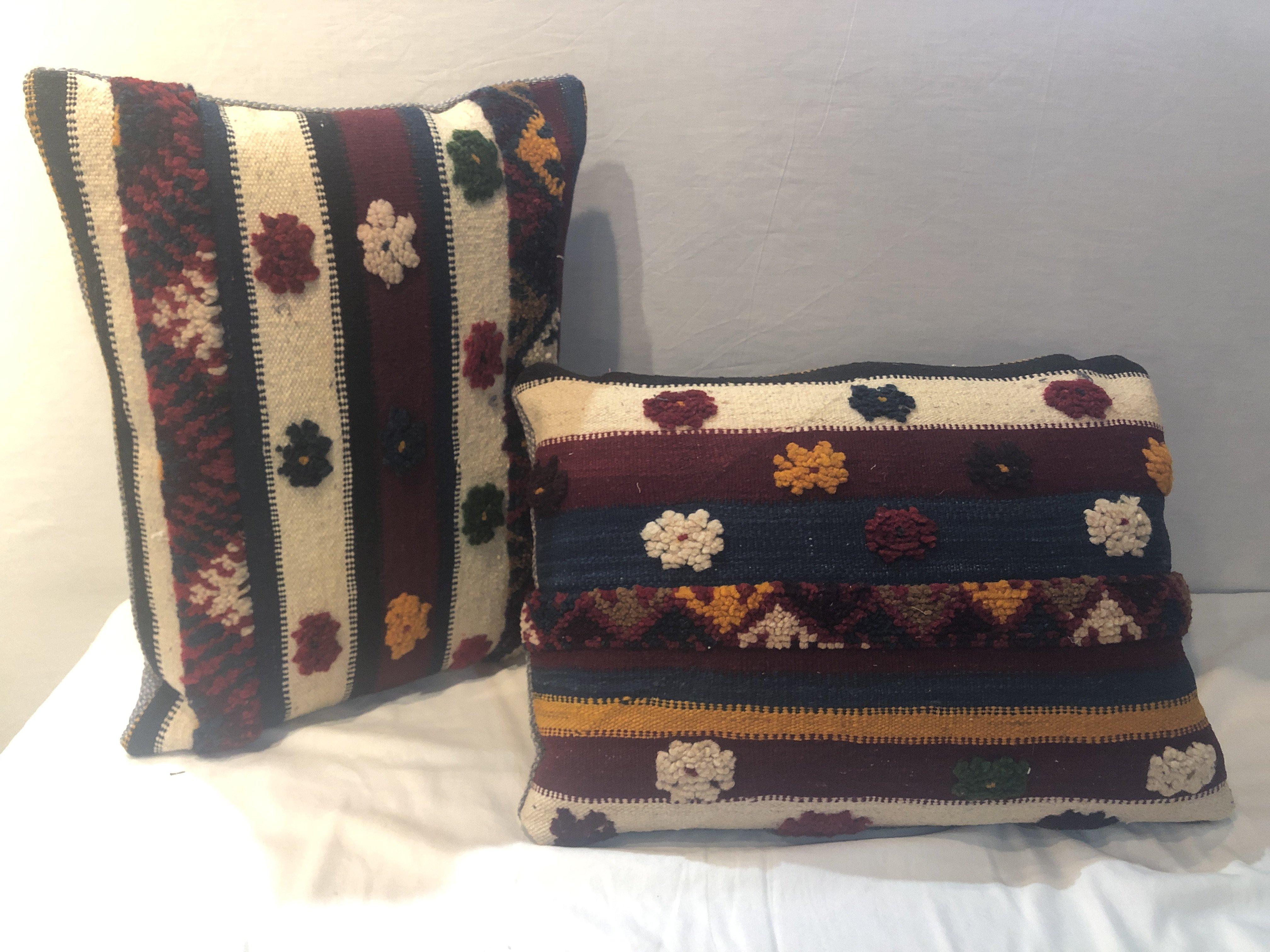 Featuring vivid and earthy burgundy, blue, off white and yellow mustard colors, this stunning one-of-a-kind pair of Kilim pillows are custom made from a vintage Moroccan wool rug handwoven in the Atlas Mountains in Morocco by Berber women