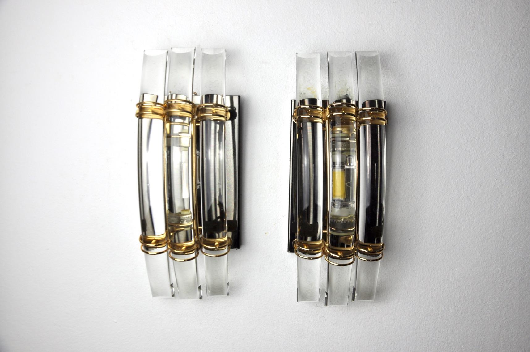 Very nice pair of wall lights in the style of Venini produced in Italy in the 70s. Murano glass and structure in black lacquered and gilded metal. Unique design object that will illuminate wonderfully and bring a real design touch to your interior.