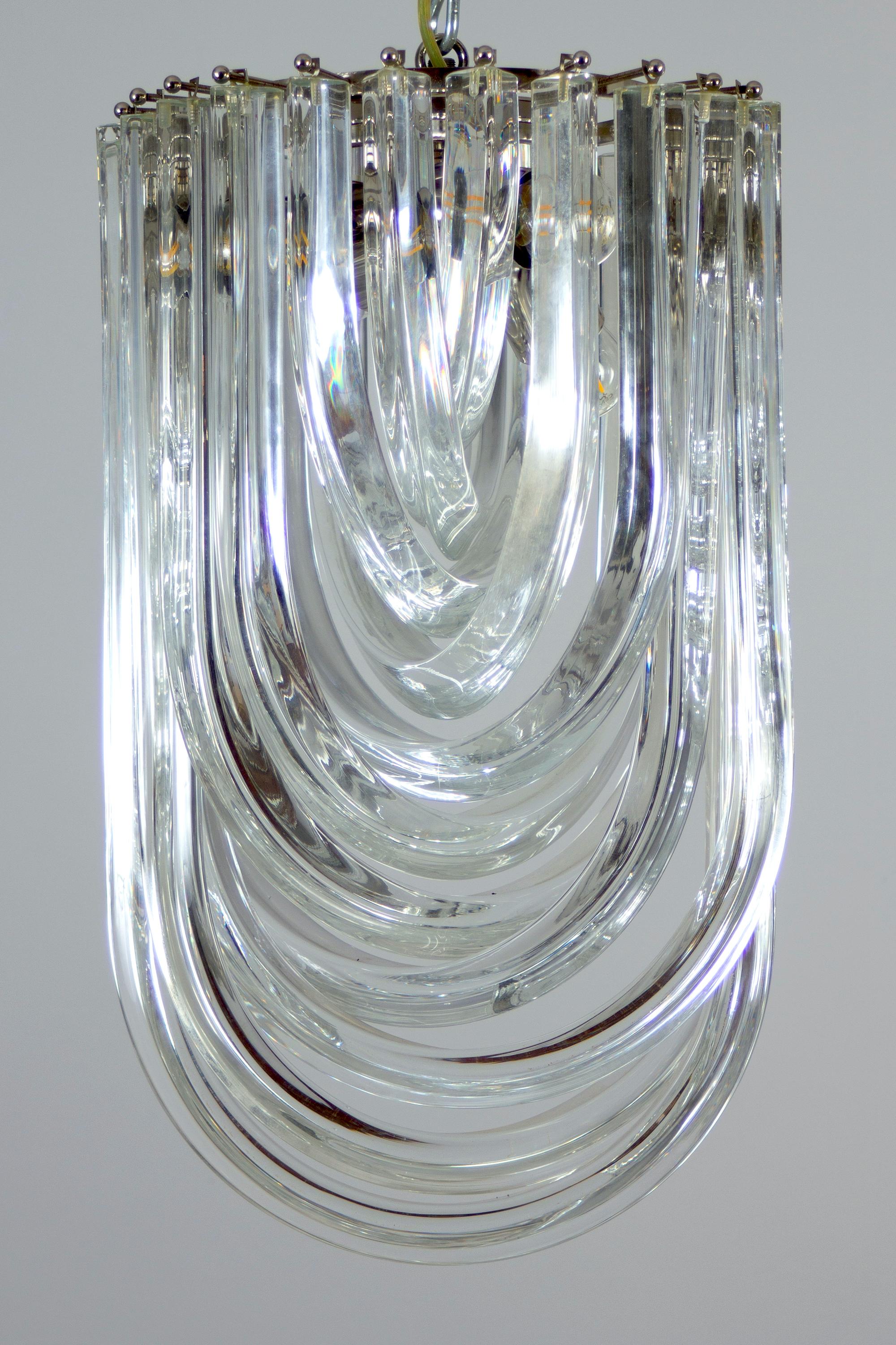 Amazing pair of glass chandelier or ceiling light with four layers of curving “triedri” glass prisms on a brass frame, designed by Carlo Nason for Venini, Italy.
A dynamic form, changing as you move around it, due to the overlapping levels of