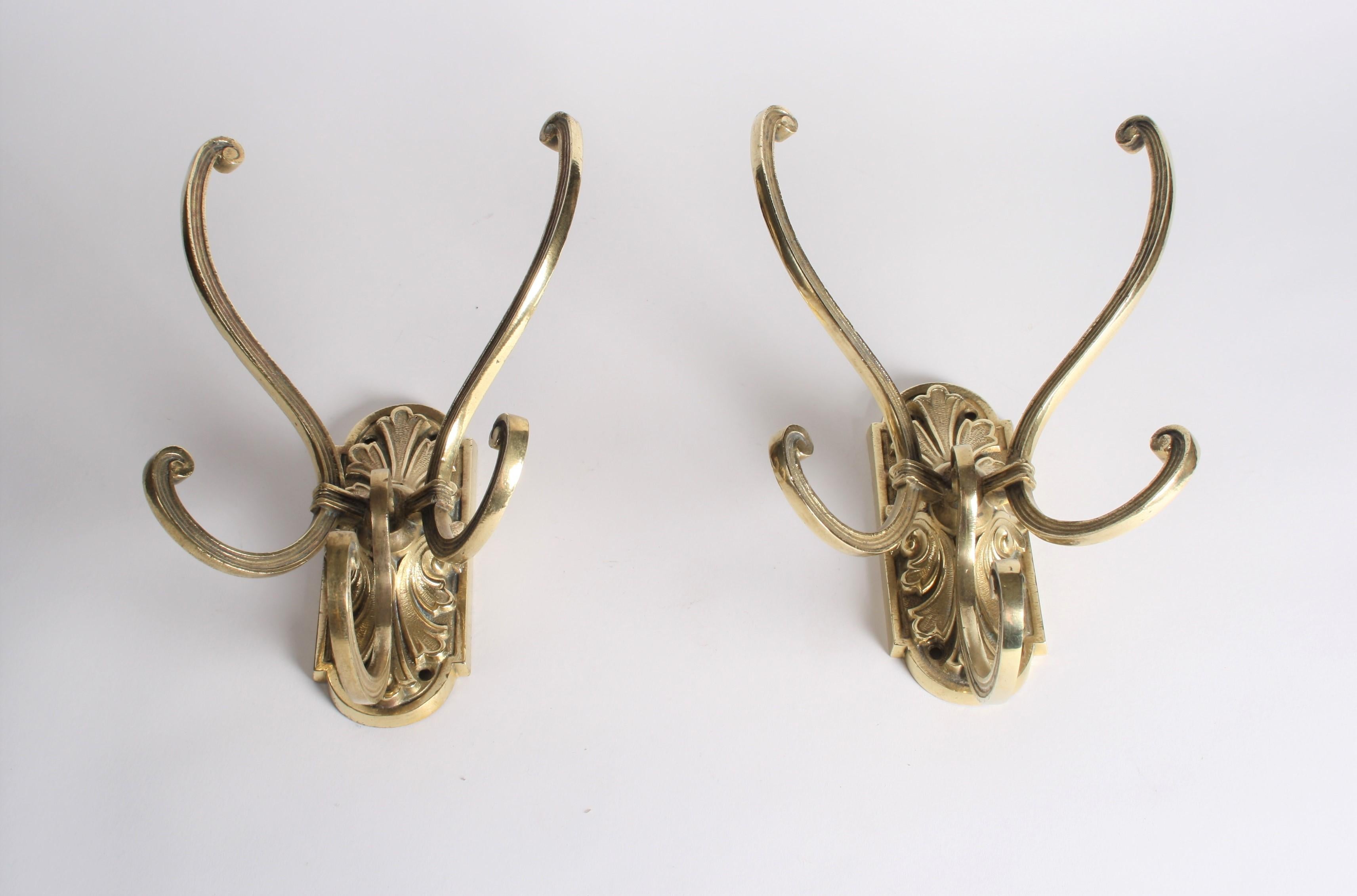 A pair of good quality brass triple hat and coat hooks with acanthus motif back plates.