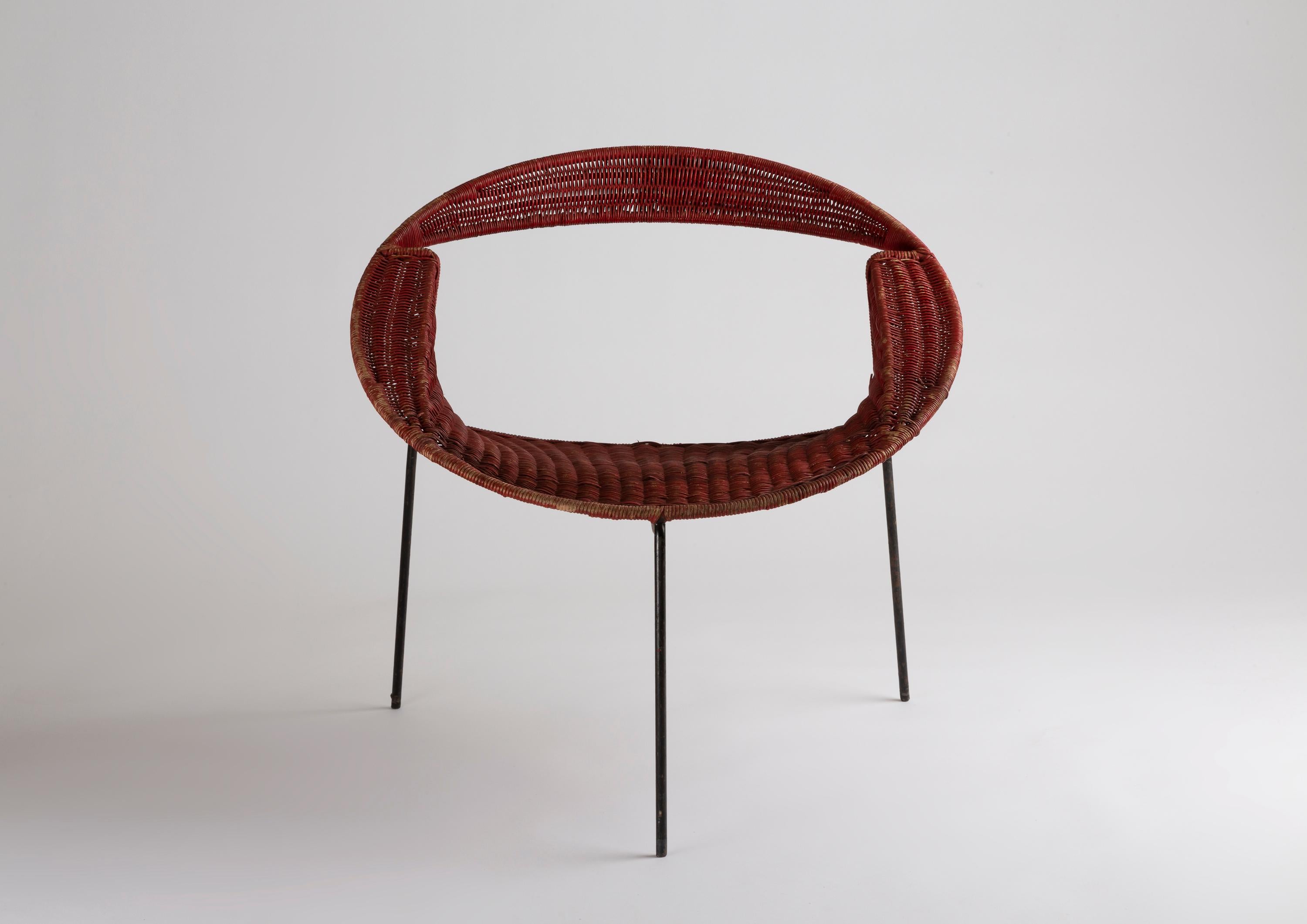 A pair of tripod armchairs by Maurizio Tempestini, in black lacquered metal and red patinated rattan, manufactured by Salterini, Italy, circa 1955.